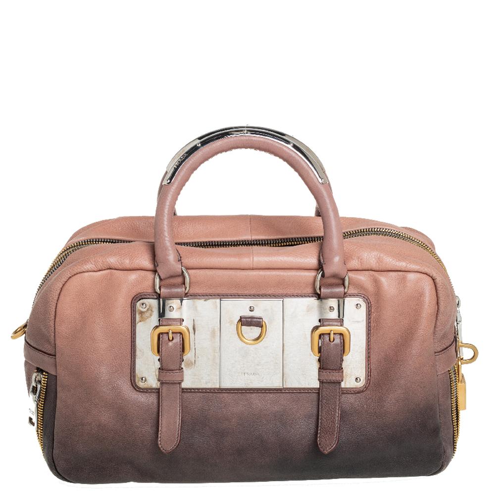 Prada’s Bauletto bag delivers a refined style through leather and a mix of gold-tone and silver-tone hardware. It comes with dual handles for your convenience and an ombre brown exterior. This stylish bag is roomy enough to hold all your daily