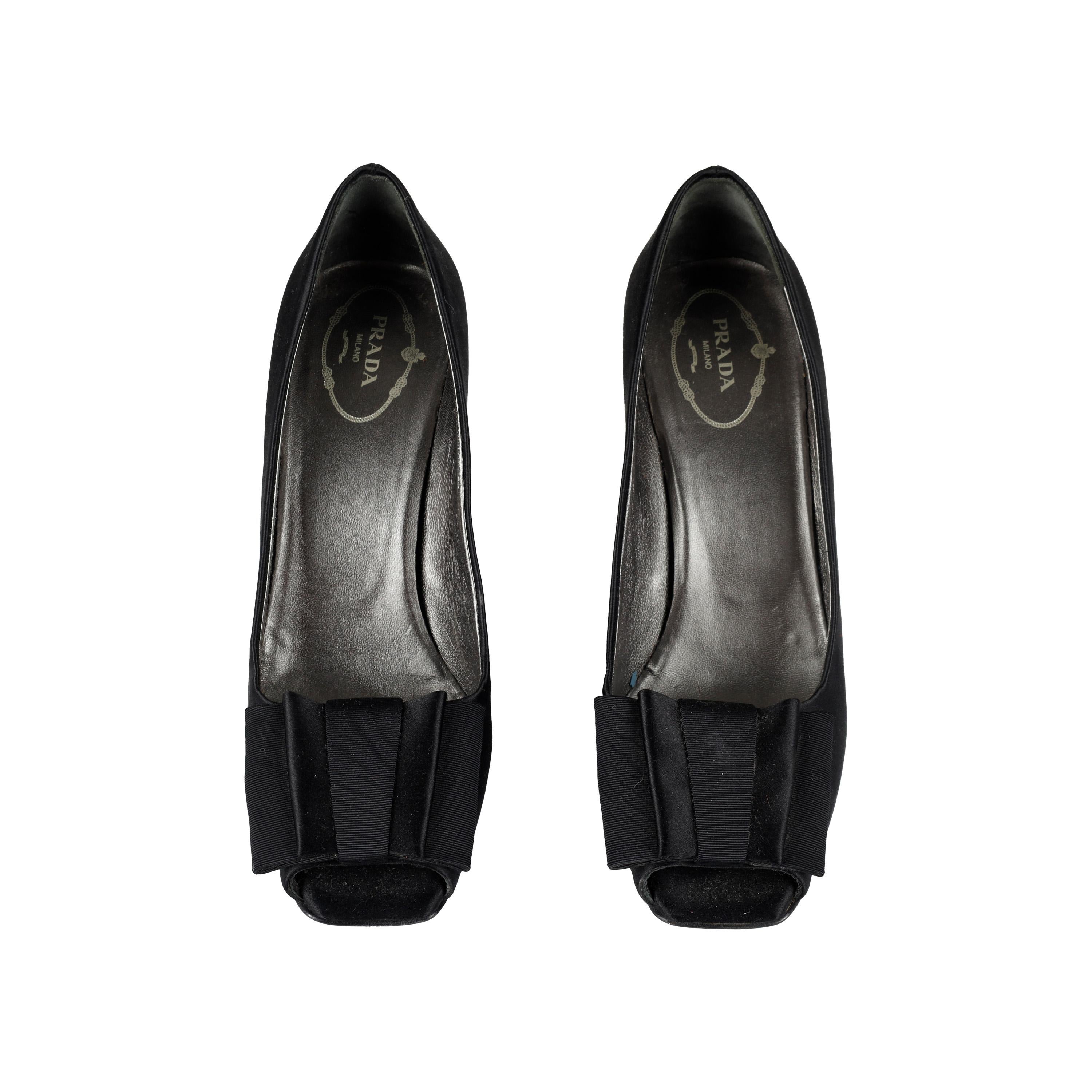 Elevate your look with Prada's Open Toe Pumps. Crafted in luxurious satin, this sleek design features a thin heel and an open-toe profile with a flat bow at the upper. The perfect addition to any wardrobe.

Remarks: There are some signs of wear.