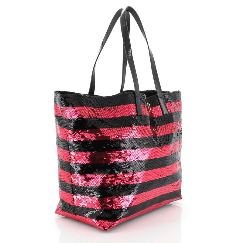 This Prada Open Tote Sequins Large, crafted in black and pink sequins, features dual flat patent leather handles, inverted triangle Prada logo on front, and gold-tone hardware. It opens to a black satin interior with zip pocket. 

Estimated Retail