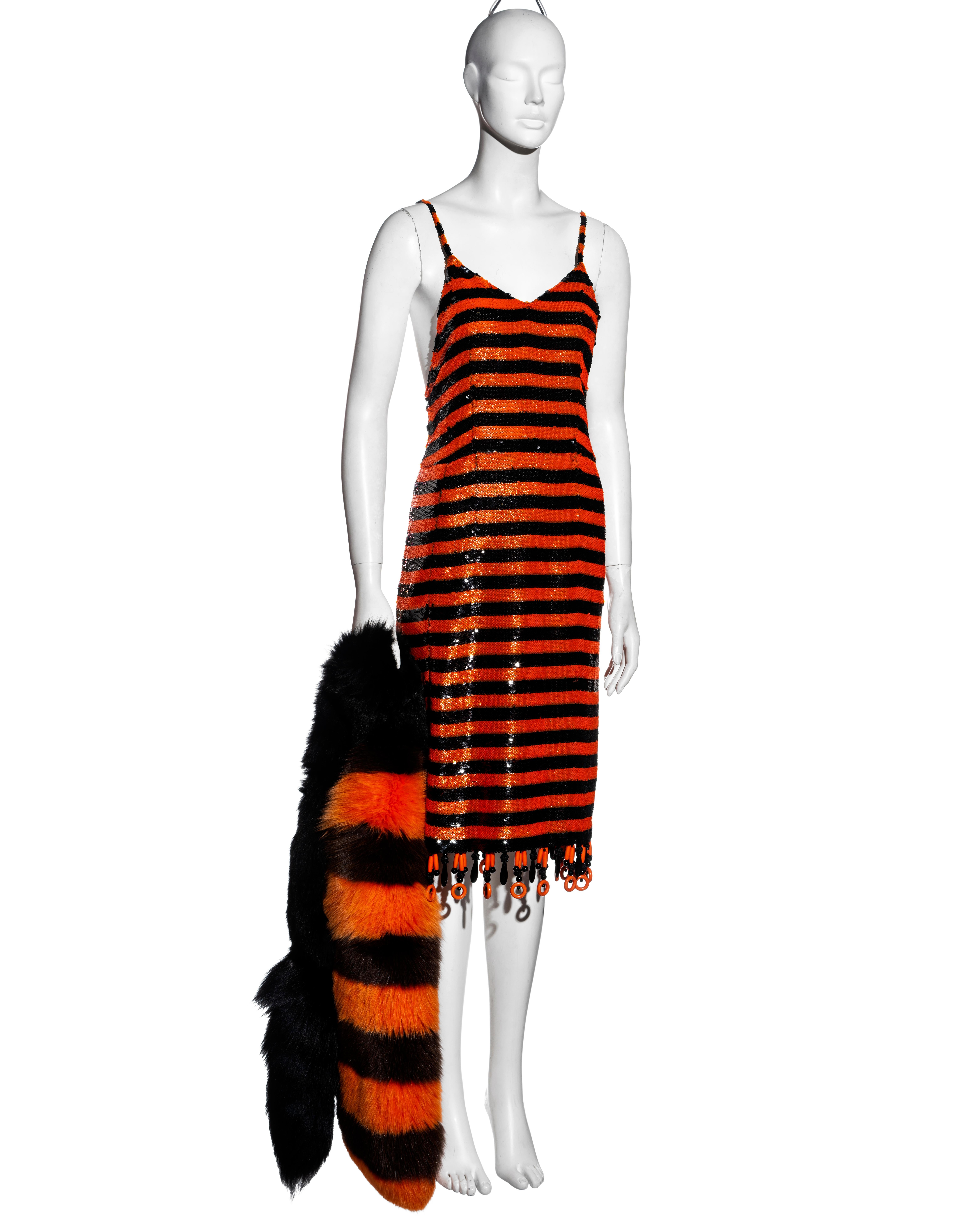 ▪ Prada orange and black striped sequin flapper dress
▪ Designed by Miuccia Prada as an exclusive piece for the Beijing SS 2011 collection 
▪ Sold with the matching large fox fur stole; an important piece of the collection
▪ Beaded tassel trim 
▪