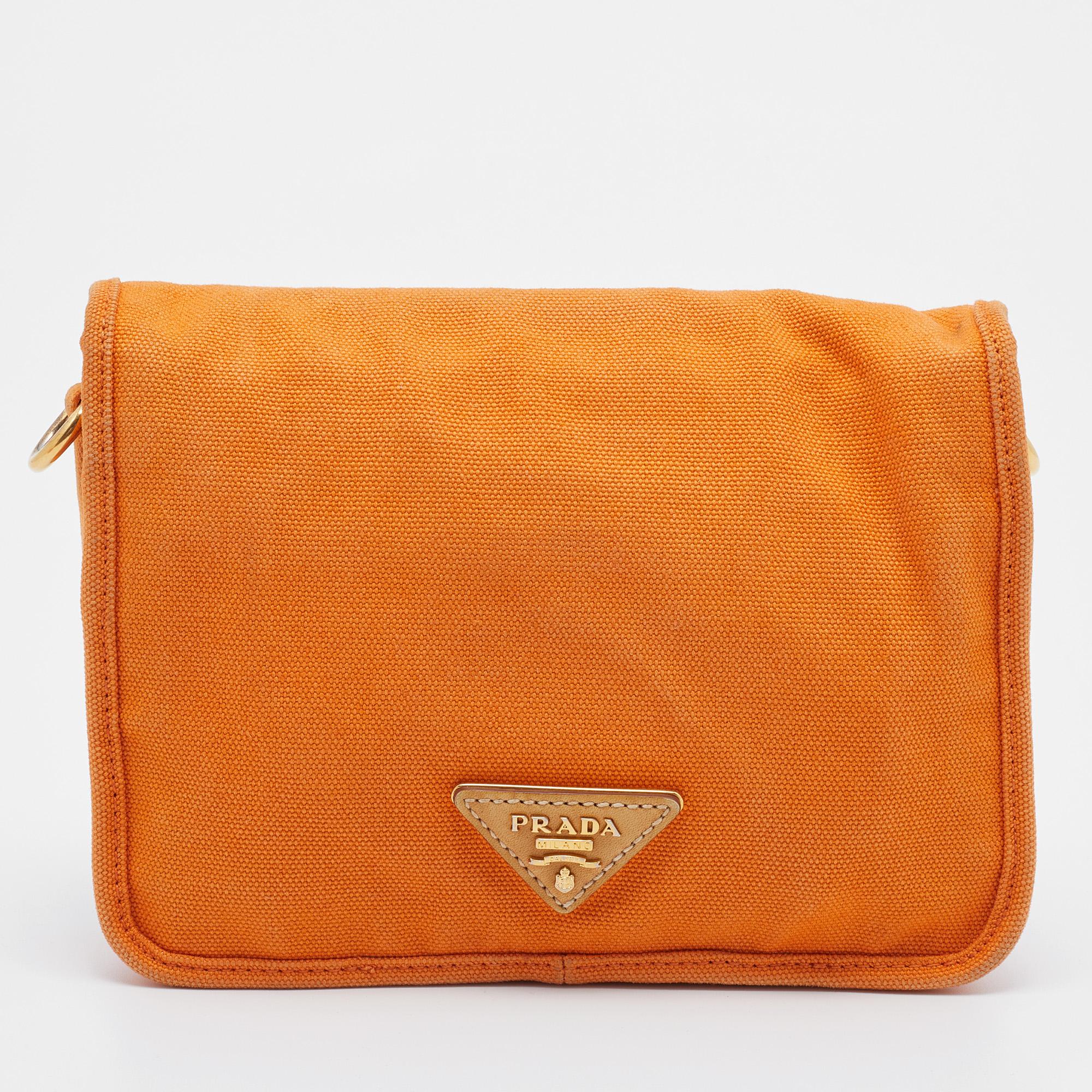 Add a bright pop of color to your outfit by flaunting this orange crossbody bag from Prada. It is crafted using canvas with leather trims and has a structured design highlighted with gold-tone details. It will look lovely with sundresses!

