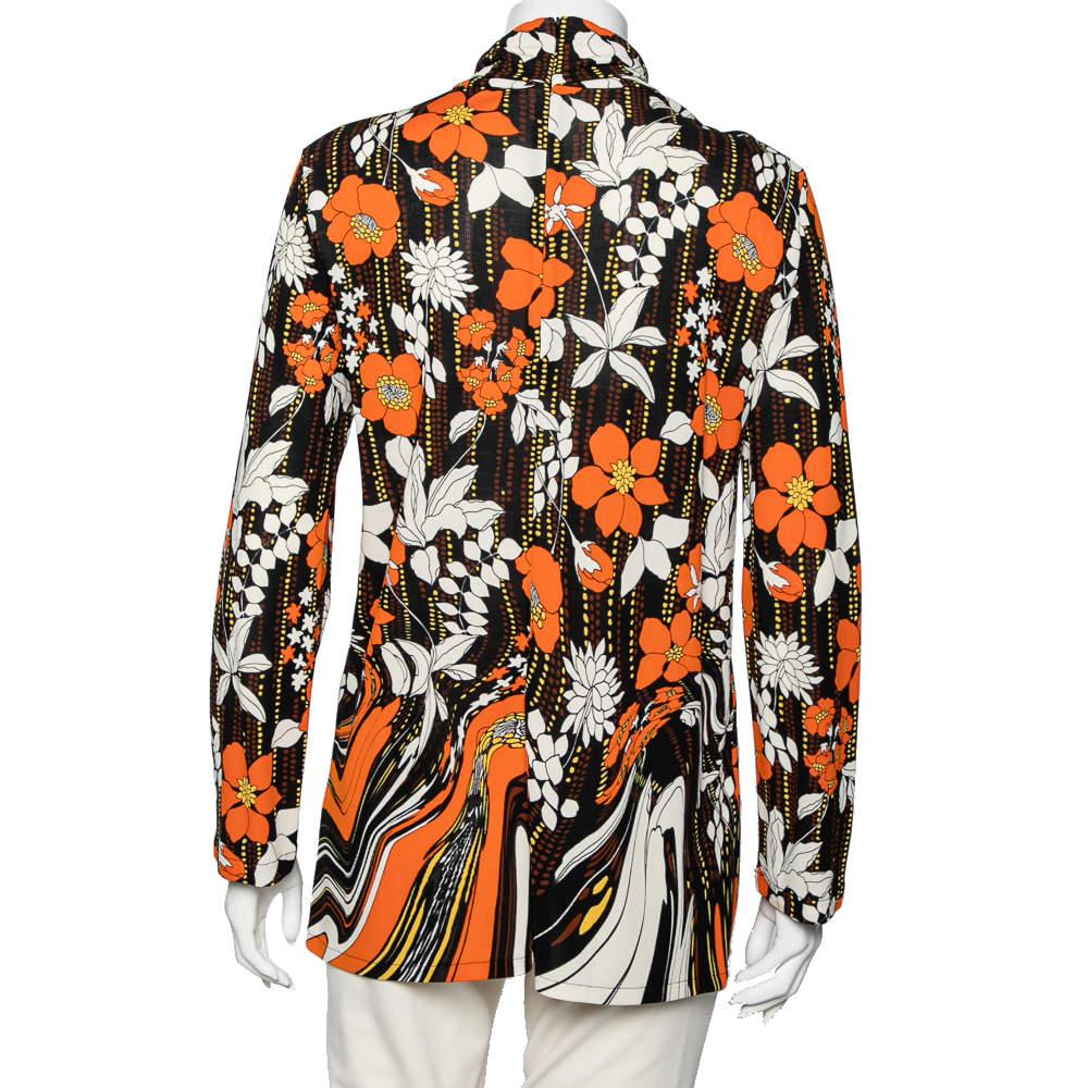 Make a classy style statement by wearing this chic top from the House of Prada. It is tailored using orange printed jersey fabric. It has a zip-type fastening, a turtleneck style, and long sleeves. This top can be complemented with a pair of black