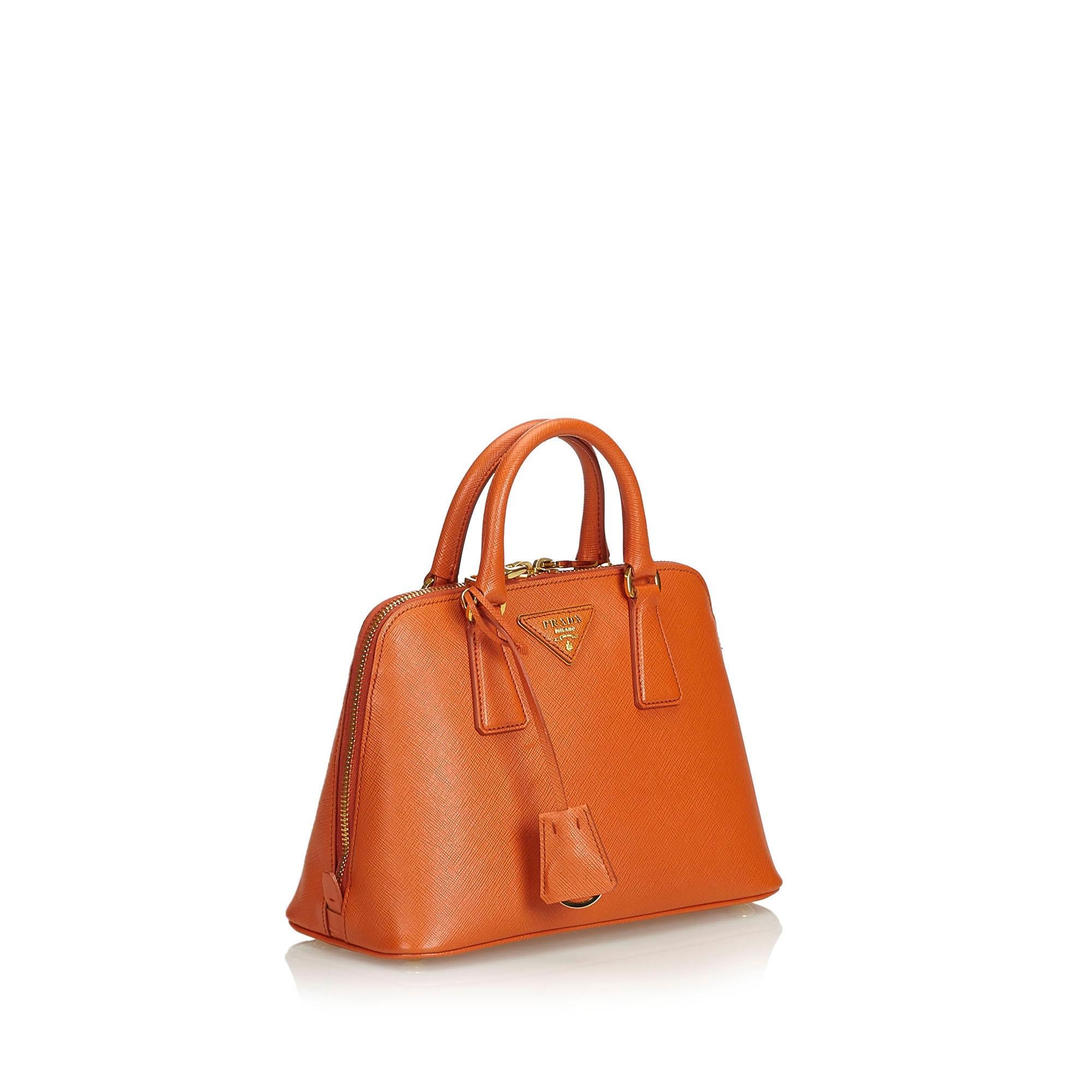 The Lux Promenade handbag features a saffiano leather body, rolled leather handles, a flat strap, a top zip closure, an interior zip compartment, and interior zip and slip pockets. It carries as A condition rating.

Inclusions: 
Dust