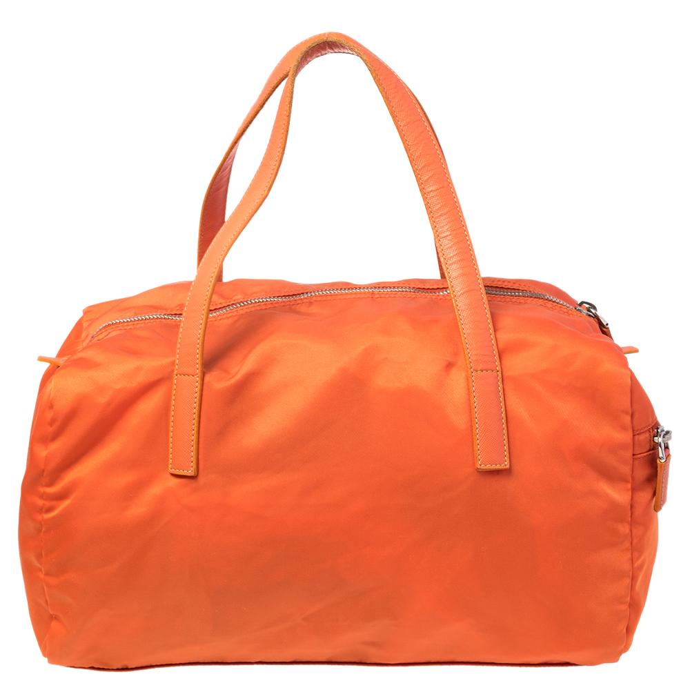 Crafted orange nylon, this Prada Boston bag can store all that you need through the day in its interior. The bag is equipped with the brand logo on the front, dual handles, and a side zip pocket.