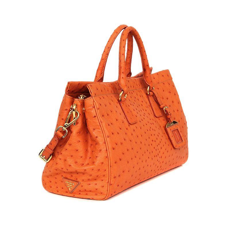 Prada handbag in orange ostrich. Adjustable and removable shoulder strap. Inside divided into two compartments by a full-size zipper pocket. Closes with a snap-button on each side. Lined in dusty rose leather with a zipper pocket against the front
