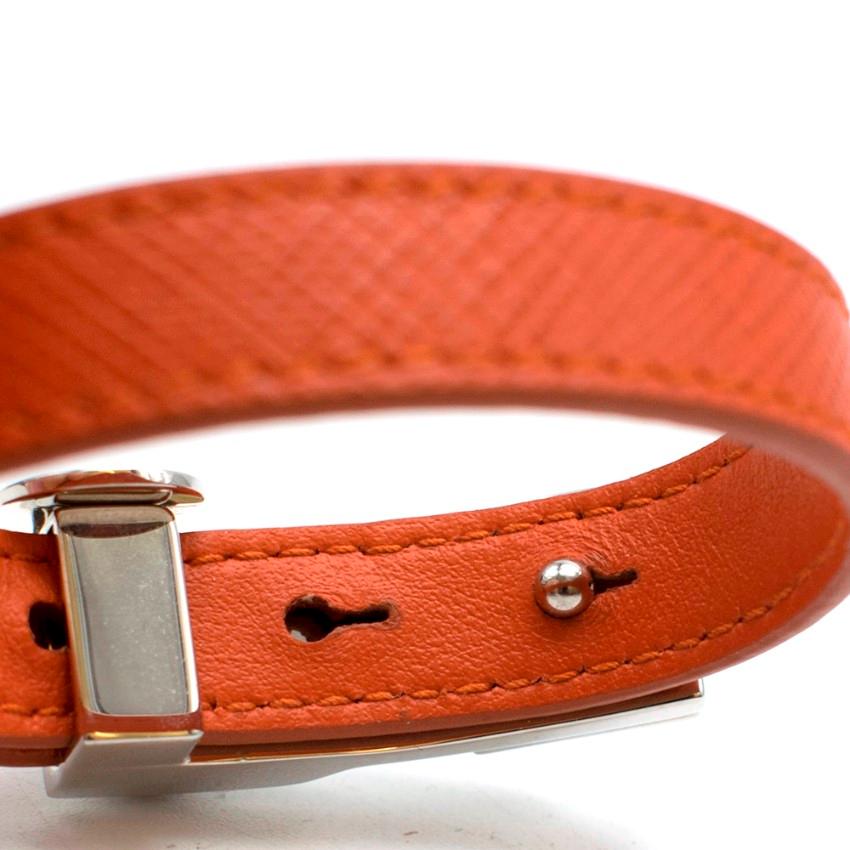 Prada Orange Saffiano Leather Studded Bracelet

- Orange Saffiano Body
- Silver tone metal stud buckle
- Small silver tone charm
- Adjustable
-Wrap push stud closure
- Box included

Please note, these items are pre-owned and may show some signs of