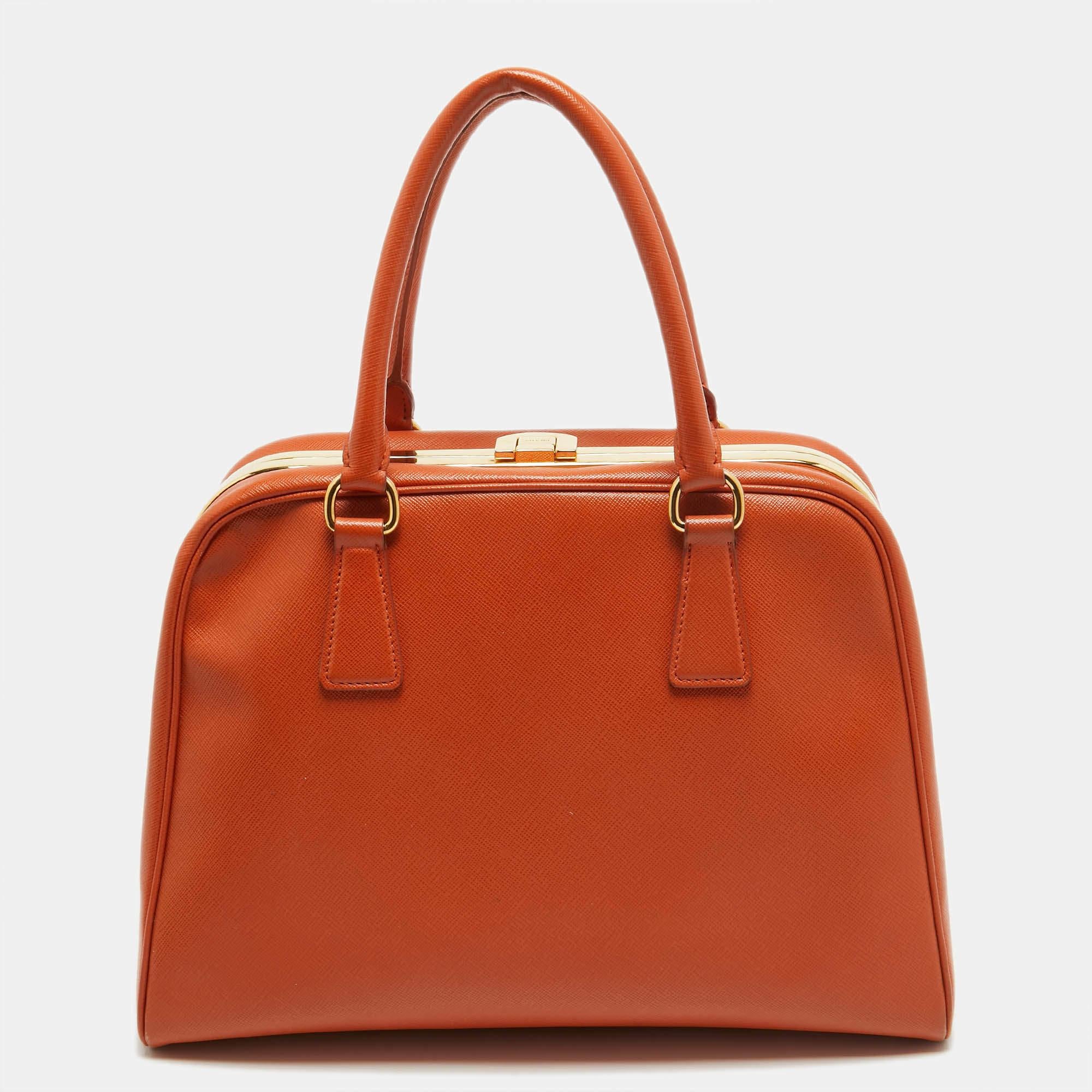 The fashion house’s tradition of excellence, coupled with modern design sensibilities, works to make this Prada orange satchel one of a kind. It's a fabulous accessory for everyday use.

Includes: Authenticity Card, Info Booklet
