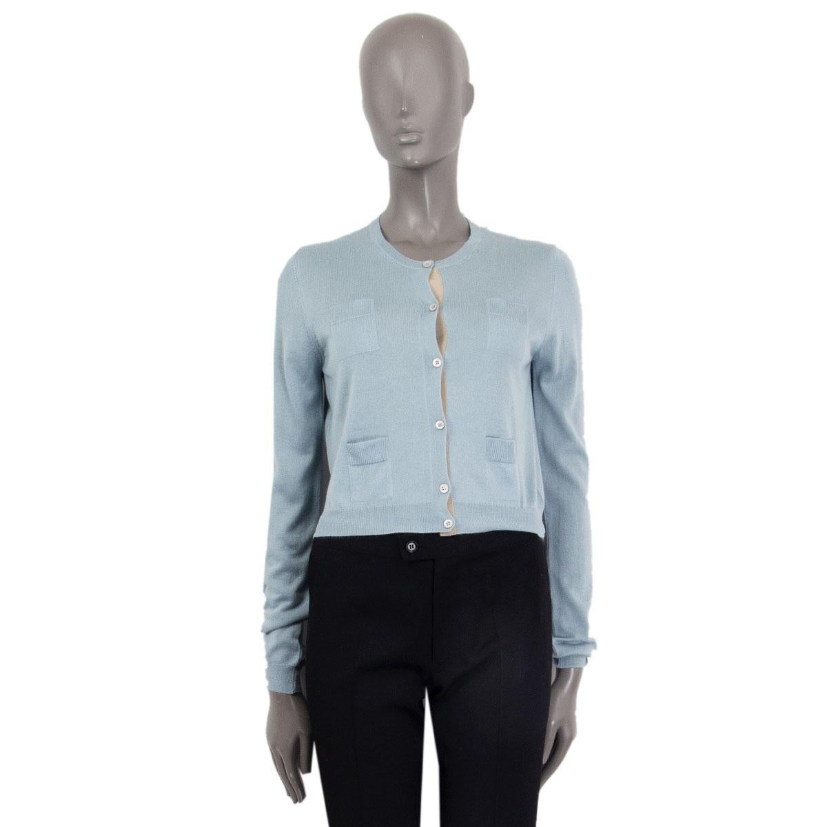 Prada cropped button-up cardigan in pale blue cashmere (70%) and silk (30%) with pale beige button tape and four patch pockets. Has been worn and is in excellent condition. 

Tag Size 42
Size M
Shoulder Width 39cm (15.2in)
Bust 96cm (37.4in)
Waist