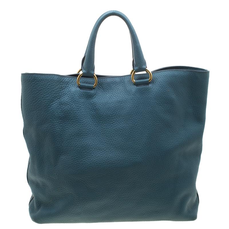 Known for its modish appeal and textured finish, this tote from Prada will be your companion for years to come. Designed into a pale blue shade, this bag can easily become a contemporary part of your collection. Ideal for coffee runs or meeting up