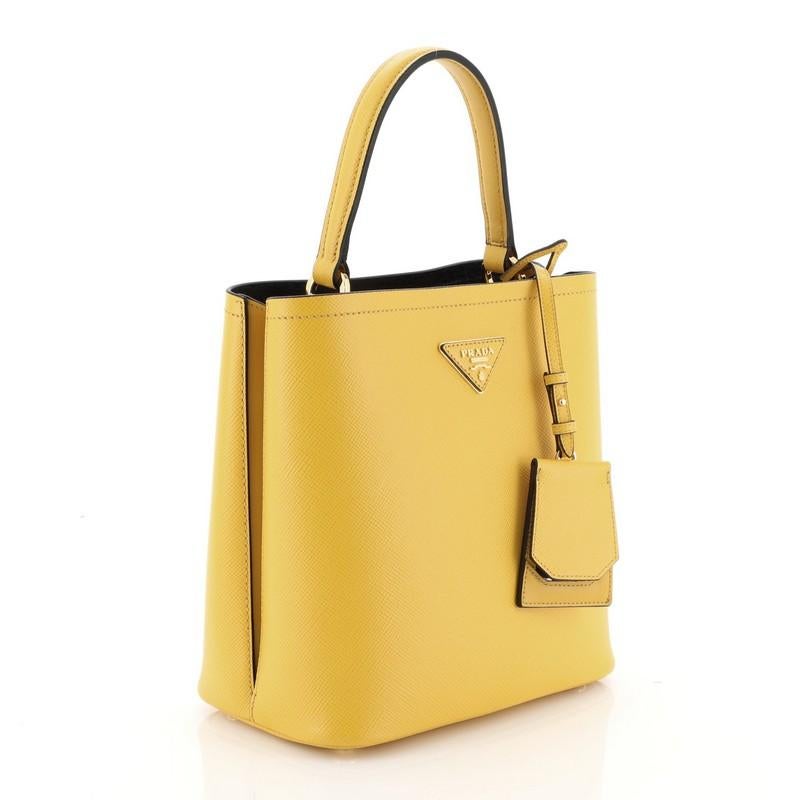 This Prada Panier Bucket Bag Saffiano Leather Medium, crafted in yellow leather, features a leather top handle and gold- tone hardware. Its wide open top showcases a black leather interior divided into two compartments.

Estimated Retail Price: