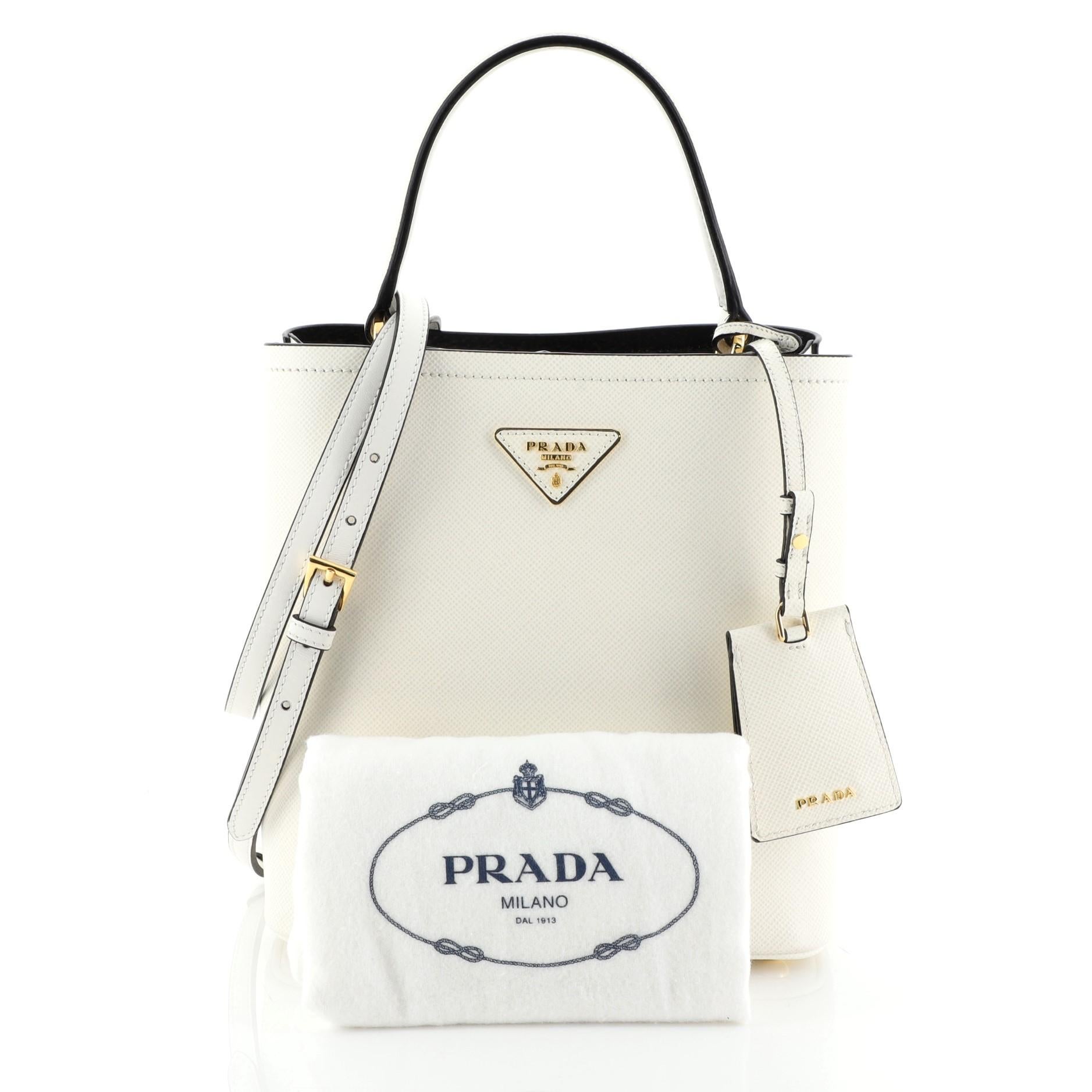 This Prada Panier Bucket Bag Saffiano Leather Medium, crafted in white leather, features a leather top handle and gold- tone hardware. Its wide open top showcases a black leather interior divided into two compartments. 


Estimated Retail Price: