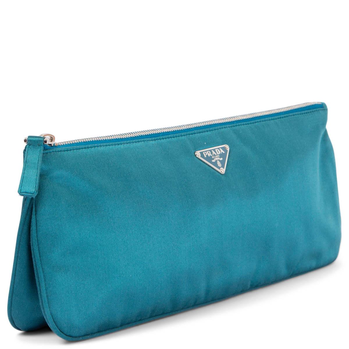 100% authentic Prada evening clutch in light petrol silk satin featuring silver-tone hardware. Opens with a zipper on top and is lined in light petrol silk with one small pocket and pocket mirror against the back. Has been carried and is in