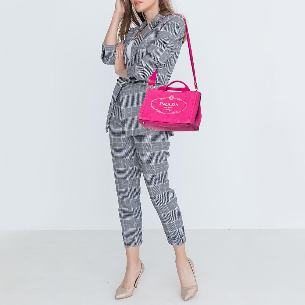 One of the most iconic designs from the house of Prada, this Canapa tote is great to wear through the day or at your vacations and never compromise style. Crafted in pink canvas fabric, this bag features the logo printed at the front face with the