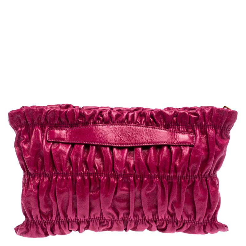 Have all eyes on you when you flaunt this stylish clutch by Prada. Crafted from pink-colored leather, it carries a gathered design all over the front. The Italian made beauty has a top-zip closure that opens to a nylon-lined interior to hold your