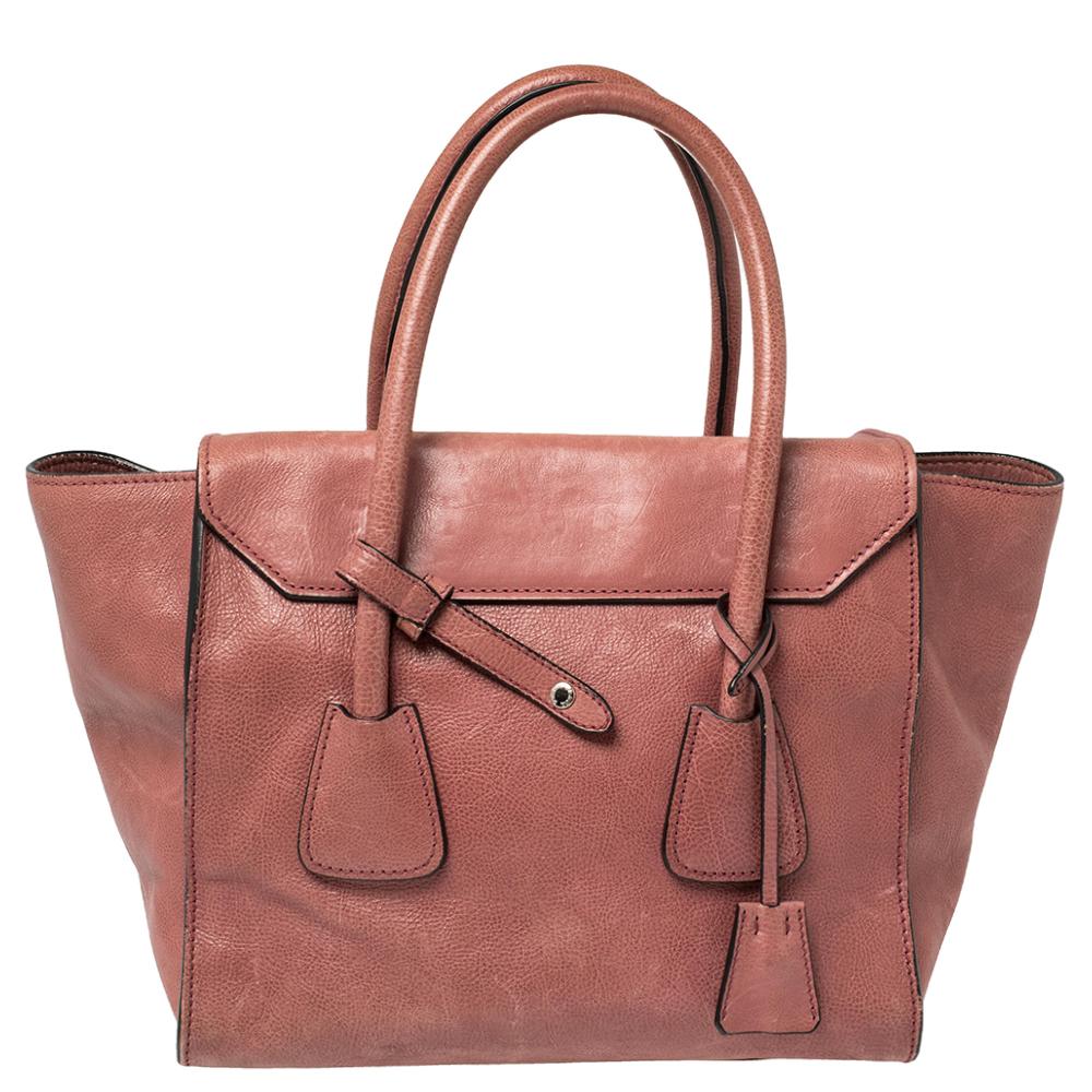 Incredibly stylish and high on functionality, this Prada tote will be the perfect pal for your daily errands! It has been crafted from pink glace leather and designed with a silver-tone lock on the front. It flaunts dual top handles and a detachable