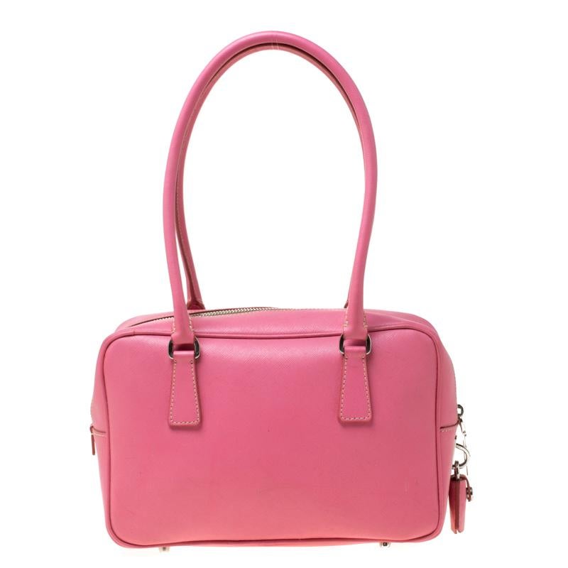 This Bowler bag from Prada is simple in design but highly functional. Crafted from pink saffiano leather, the bag features two handles, silver-tone hardware and a top zipper leading to a nylon interior for your necessities. The bag will be a luxe
