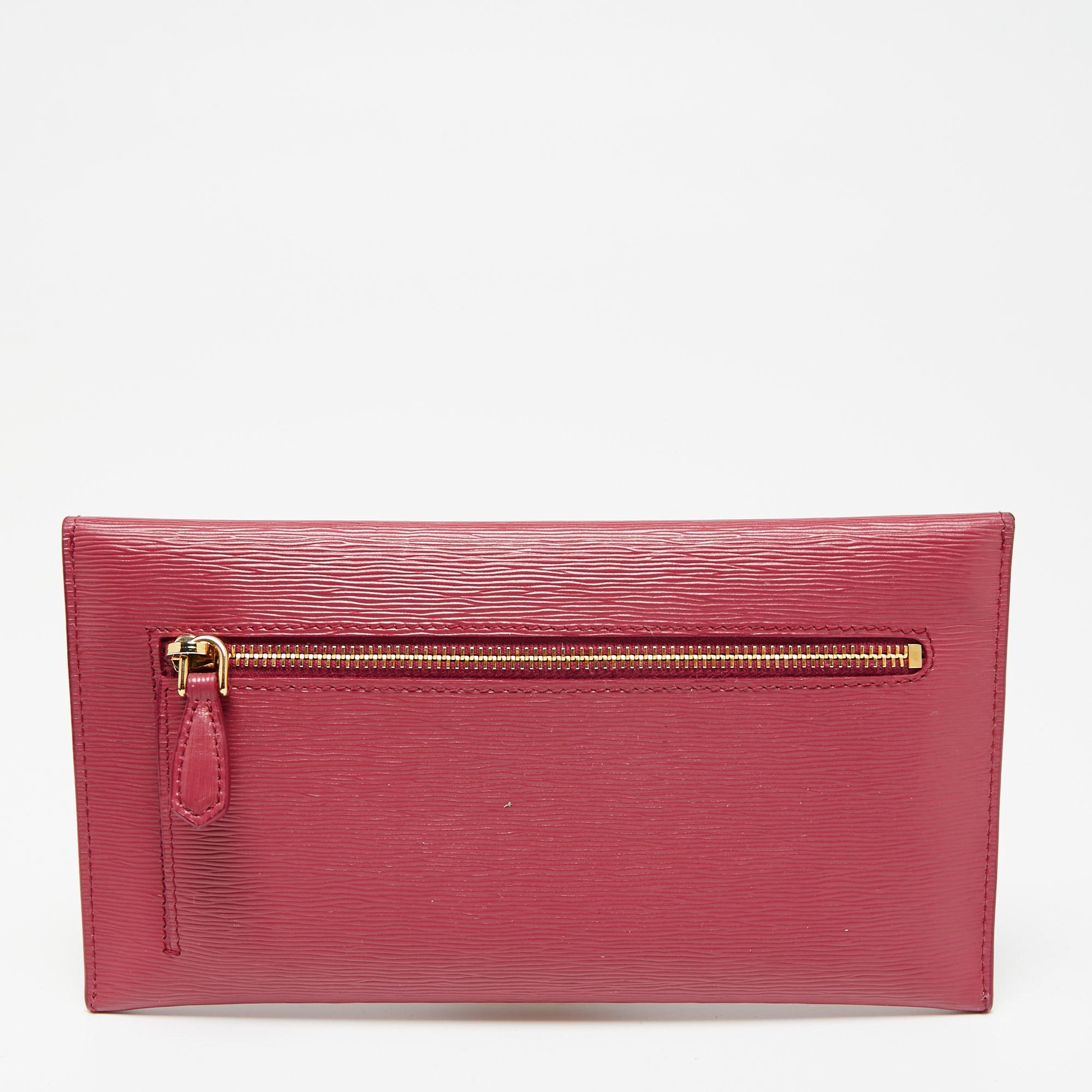 Prada's envelope wallet is equipped with card slots and enough space to neatly house essentials. It features a pink Saffiano leather body, detailed with the brand logo in gold-tone metal on the flap. The sleek style looks good hand-held and also