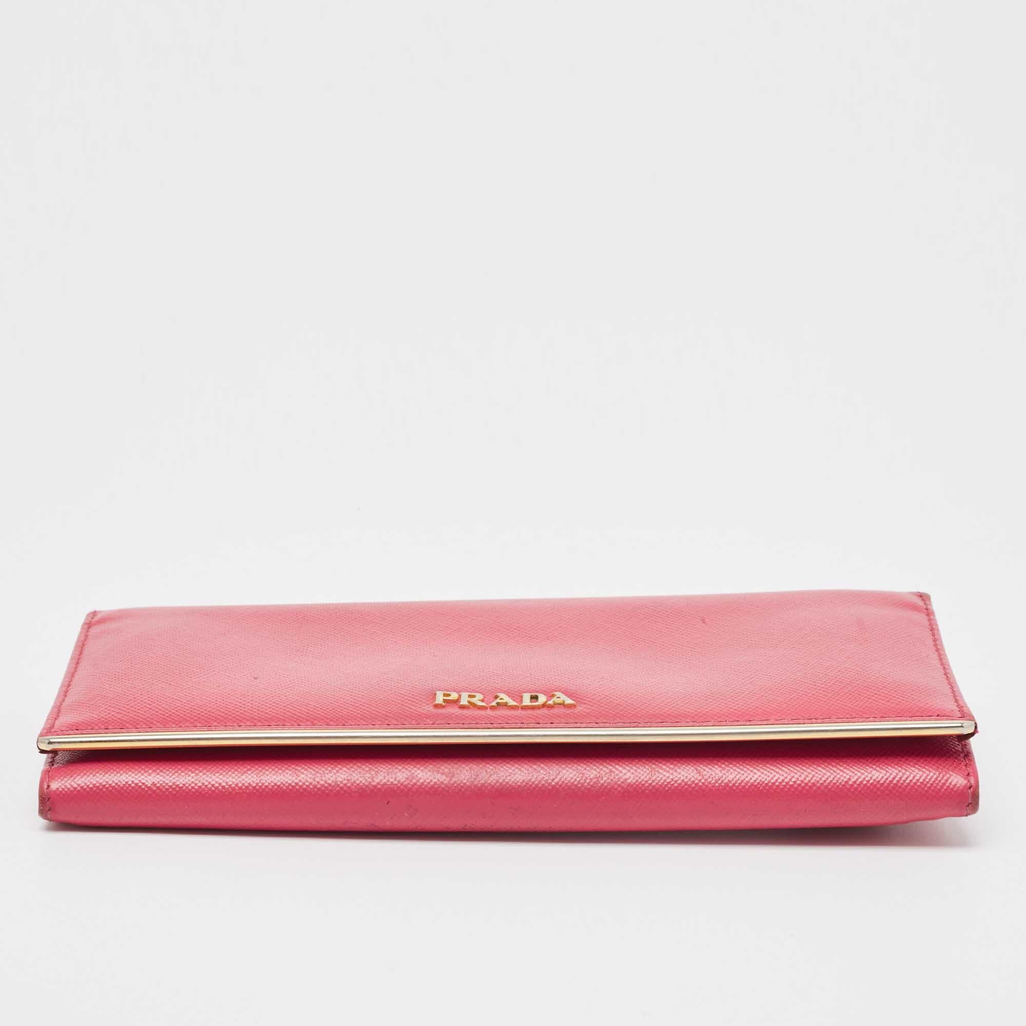 A sophisticated wallet, crafted in blush pink Saffiano leather is the season’s new style statement. This continental flap wallet by Prada features metal detailing. The front flap closure opens to a leather & fabric-lined interior and has card slots