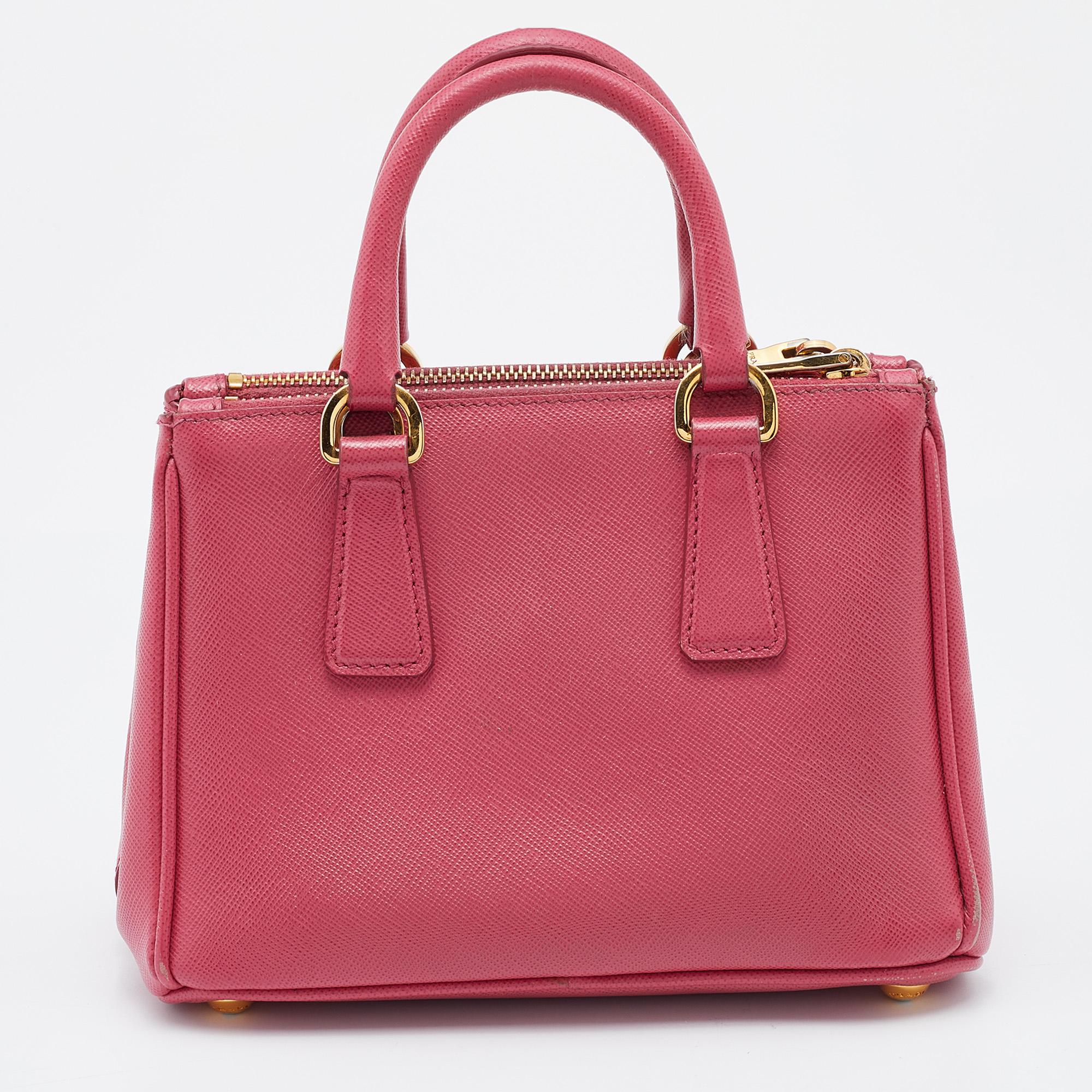 Loved for its classic appeal and functional design, Galleria is one of the most iconic and popular bags from Prada. This beauty in pink is crafted from Saffiano leather and is equipped with two top handles and the brand logo at the front. The