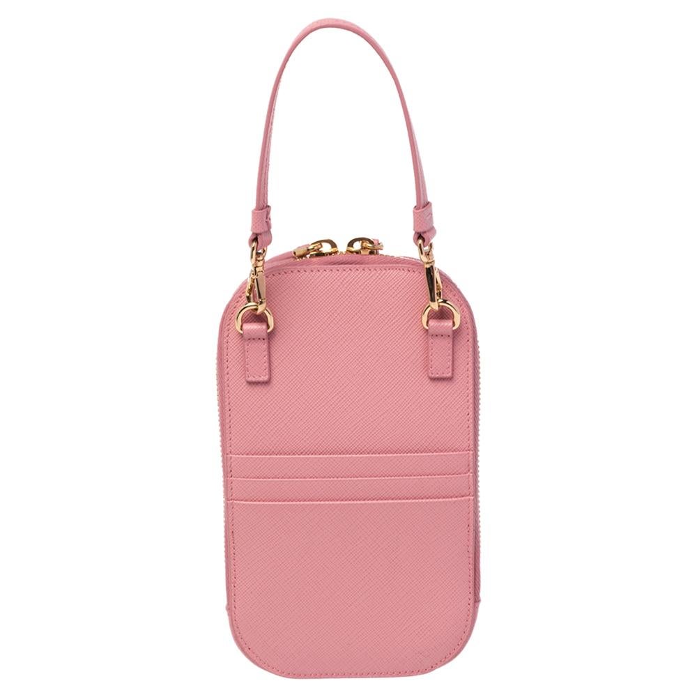 Carry your phone in the sweetest phone pouch by Prada. Designed using Saffiano Lux leather as a crossbody bag, the pink pouch has a zip-enclosed interior, a top handle, a detachable shoulder strap, and cute motifs at the front.

Includes: Shoulder