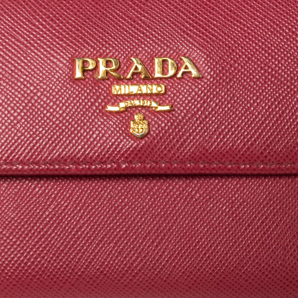 This Prada cardholder is conveniently designed for everyday use. Crafted from pink Saffiano leather, the piece comes in a flap style with a logo in gold-tone. The wallet has a bifold compartment at the back with multiple slots.

