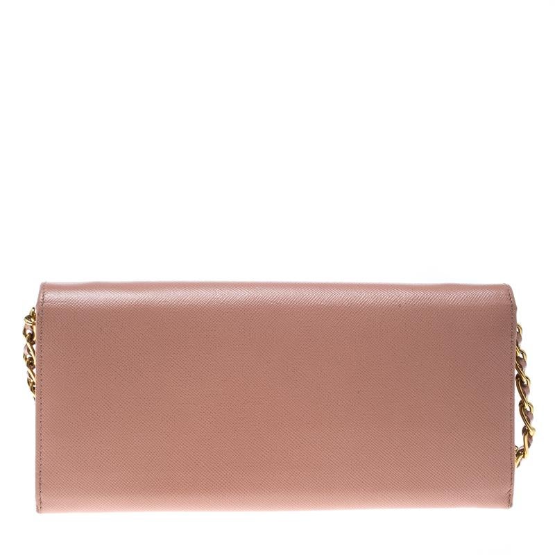 Prada brings you yet another gorgeous accessory with this wallet. It has been crafted from pink Saffiano leather and has a flap that reveals a well-sized leather lined interior with multiple card slots and a zip pocket. The lovely creation is