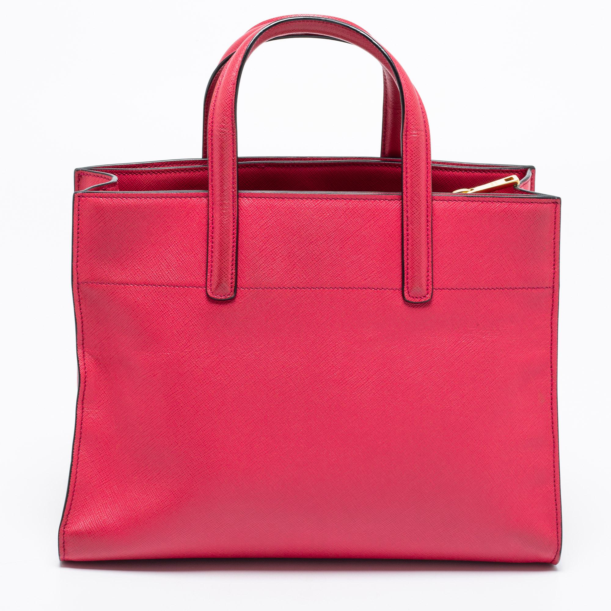 This tote from the House of Prada is great for everyday use. It is made from pink Saffiano Soft leather, which is embellished with gold-tone hardware. It showcases dual handles and a leather-nylon interior. This tote will make you look classy and