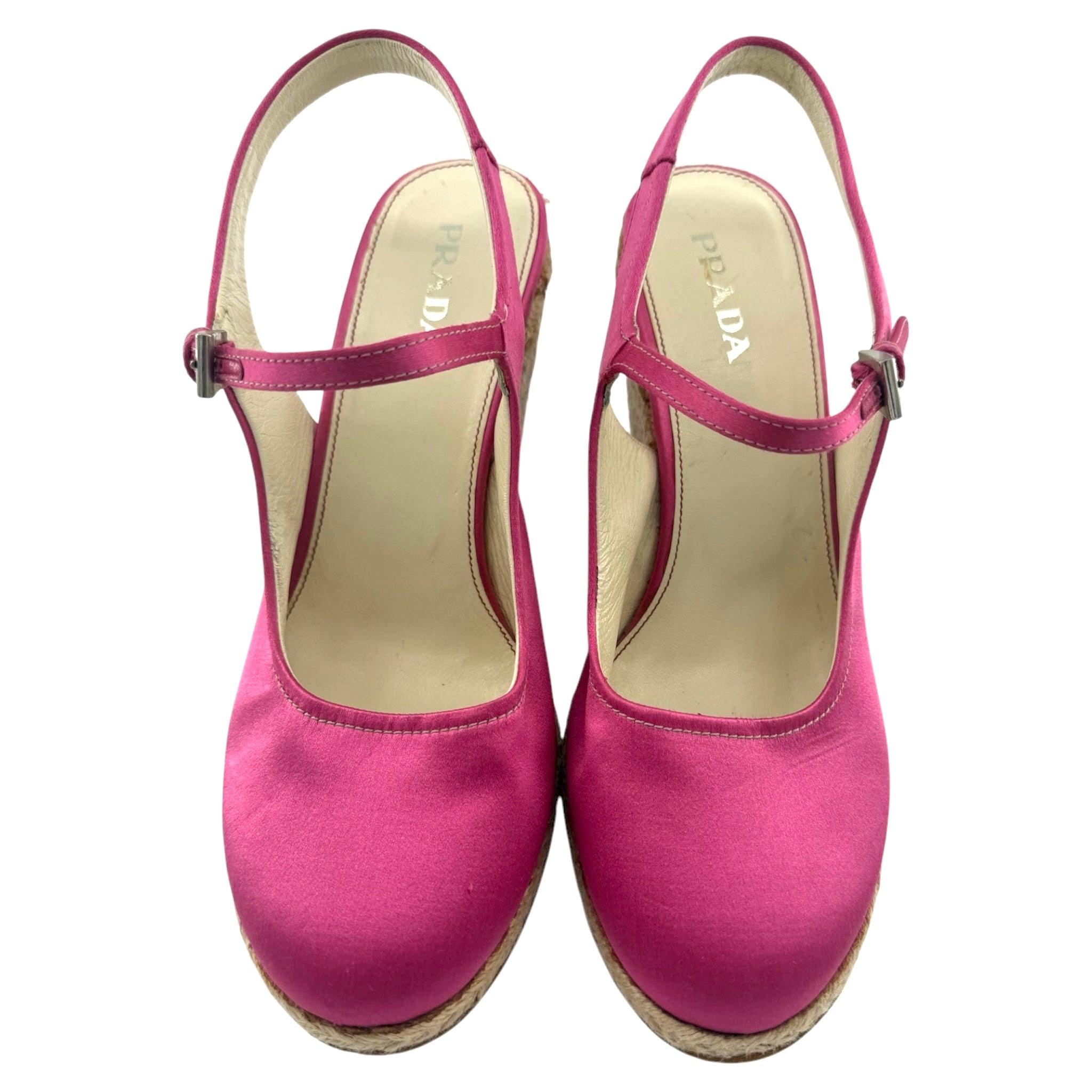 Preparati alla primavera con queste eleganti espadrillas con plateau in raso fucsia di Prada! Caratterizzate da una silhouette Mary Jane, da fibbie argentate e da una chiusura regolabile con fibbia, queste scarpe sono perfette per aggiungere un
