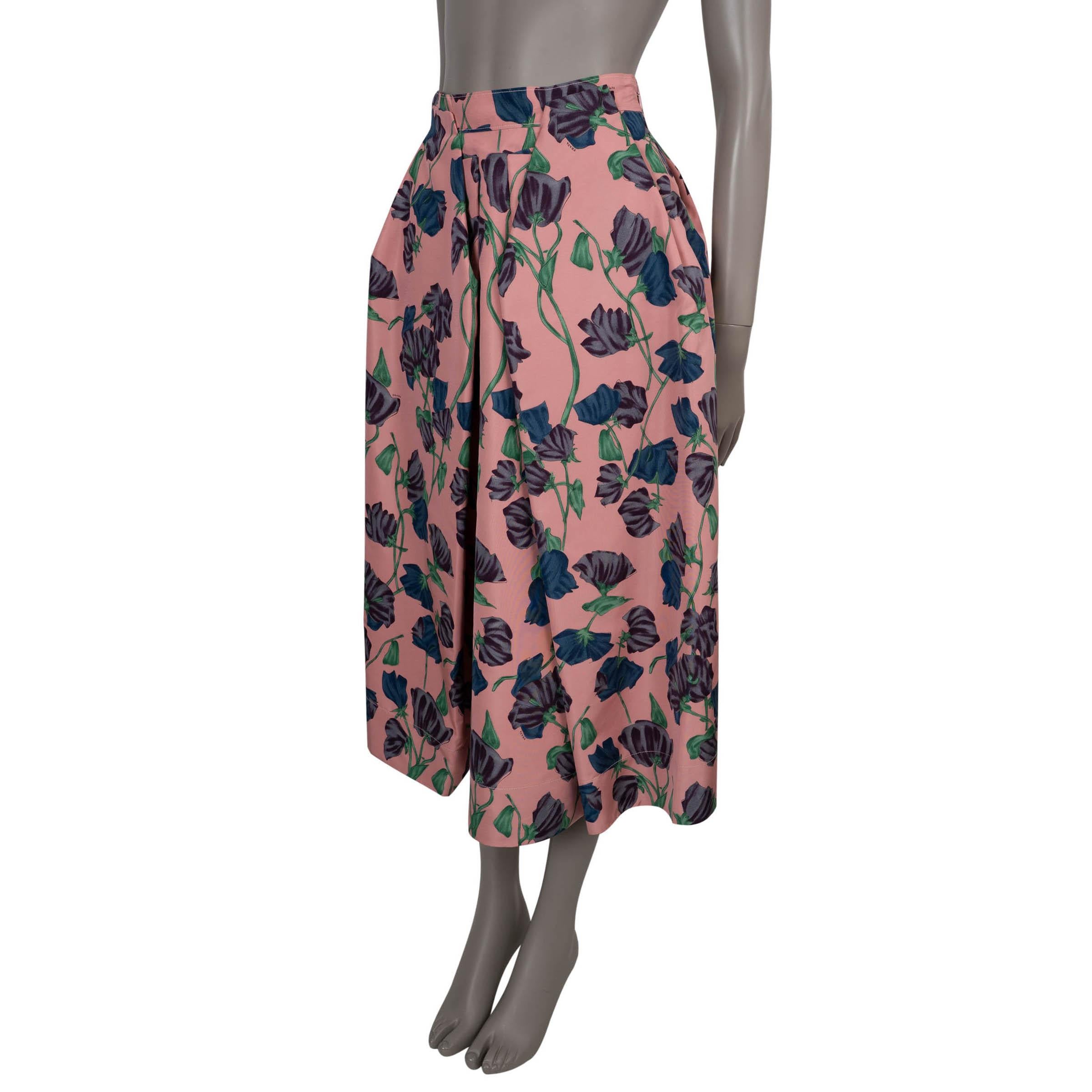 100% autentica gonna di Prada in seta rosa (100%) stampata con motivi floreali in tonalità di viola, blu e verde. Progettato con una silhouette a vita alta e splendidamente svasata che cade in una raffinata lunghezza midi, è strutturato con generose