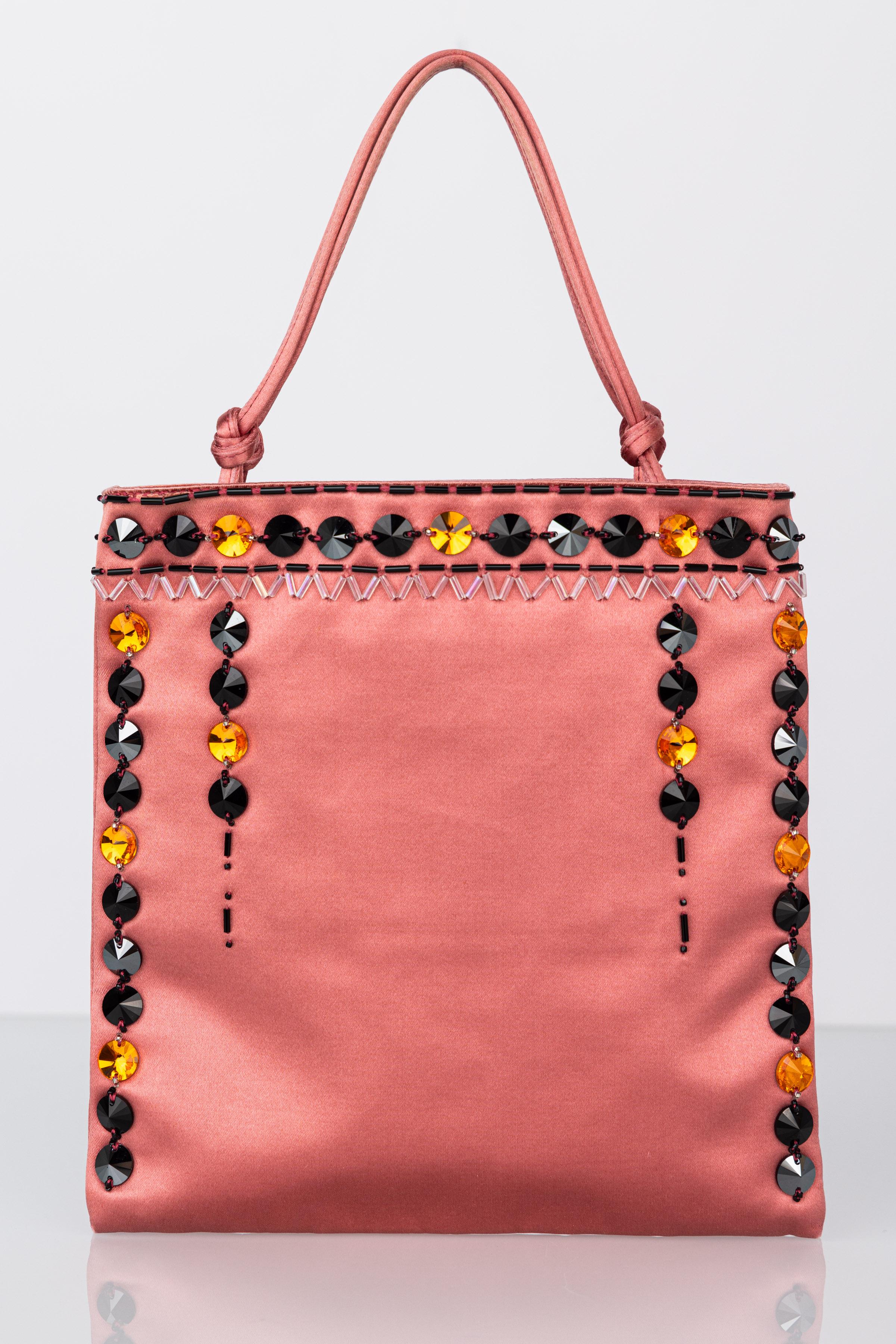 Diese Tasche von Prada ist aus rosafarbener Seide gefertigt und mit gelben, schwarzen und zinnfarbenen Kristallsteinen und Perlen besetzt. Ein geknoteter Henkel zum Tragen am Arm, perfekt für den Tag oder als Abendtasche.

Diese Tasche ist in sehr