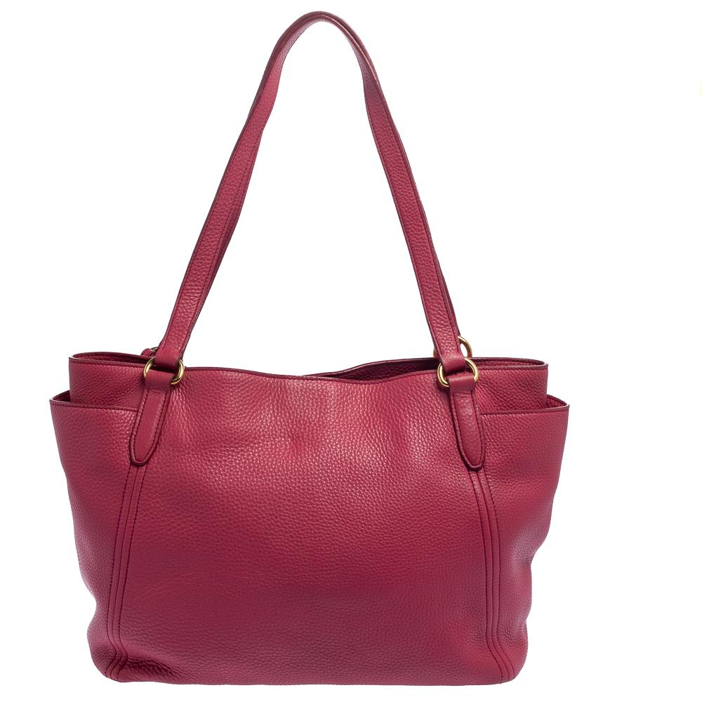 Incredibly stylish and high on functionality, this Prada tote will be the perfect pal for your daily errands! It has been crafted from pink Vitello Daino leather and designed with side pockets and the brand loo detailed on the front. It flaunts dual