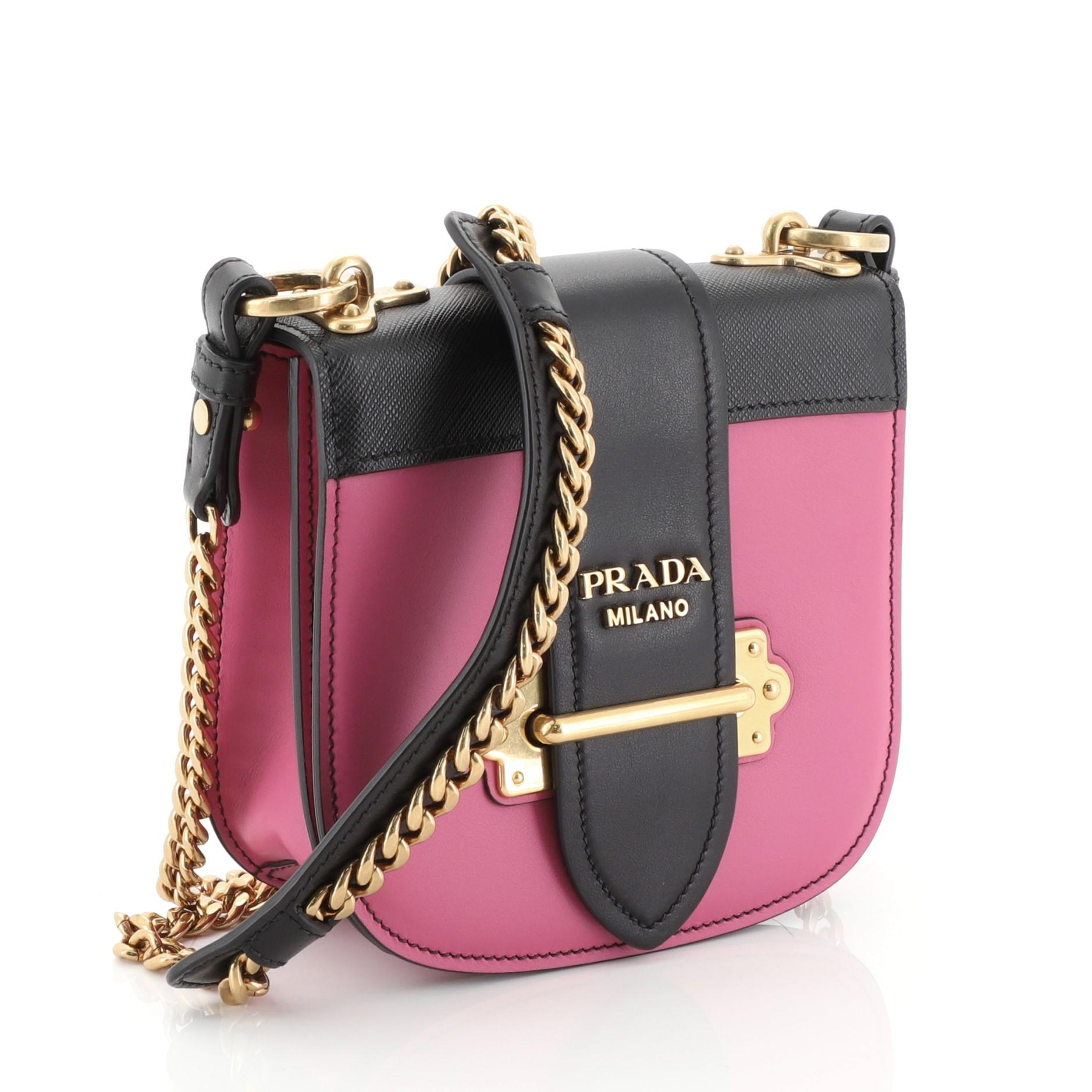 This Prada Pionniere Crossbody Bag City Calfskin with Saffiano Leather Small, crafted from pink city calf and saffiano leather, features adjustable shoulder strap, metal hardware trim, front flap and aged gold-tone hardware. Its buckle closure opens
