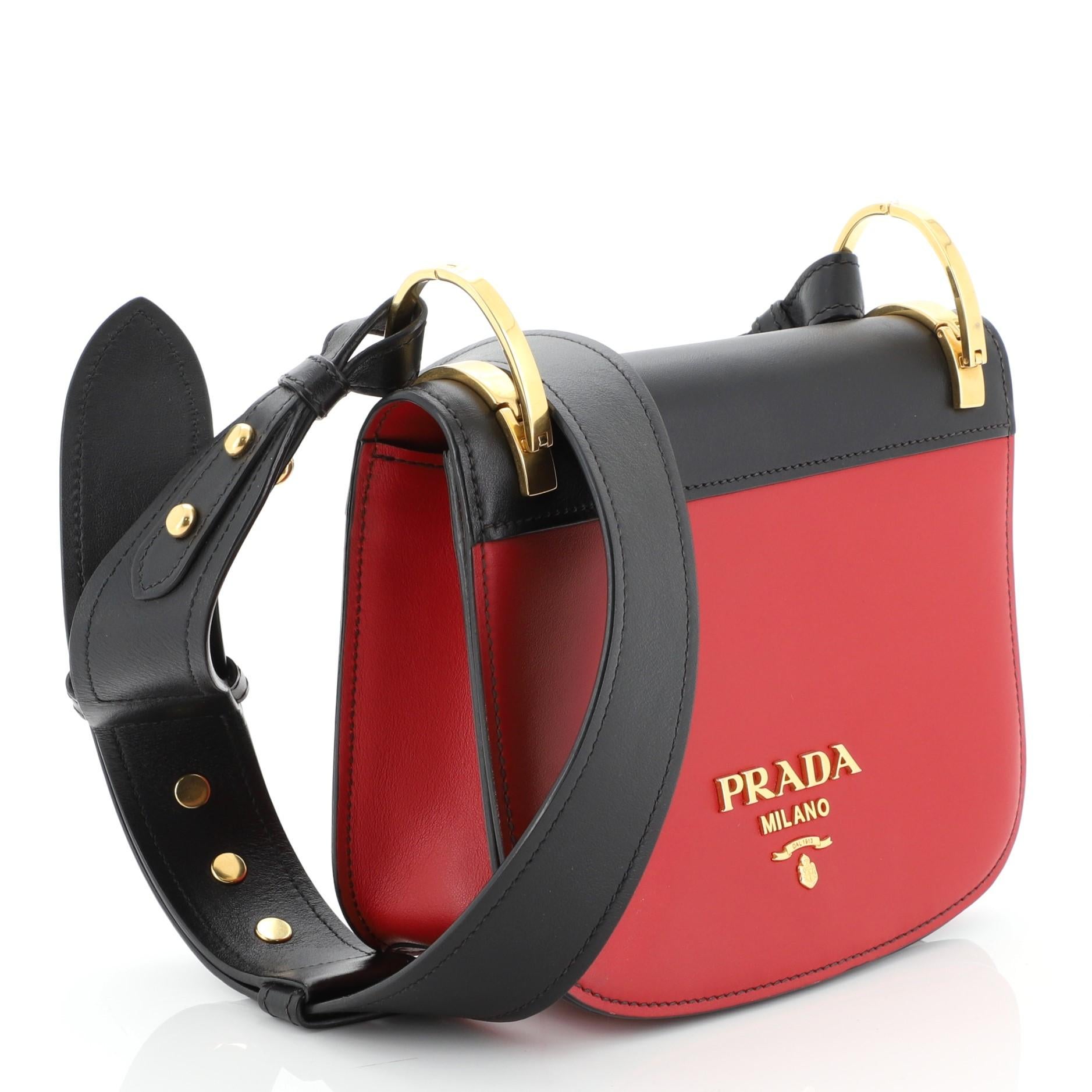 This Prada Pionniere Saddle Crossbody Bag City Calfskin Small, crafted from red leather, features an adjustable leather strap and gold-tone hardware. Its flap opens to a black leather interior with slip pocket. 

Estimated Retail Price: