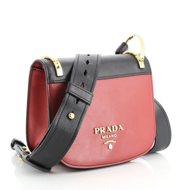 This Prada Pionniere Saddle Crossbody Bag City Calfskin Small, crafted from red leather, features an adjustable leather strap and gold-tone hardware. Its flap opens to a black leather interior with slip pocket. 

Estimated Retail Price: