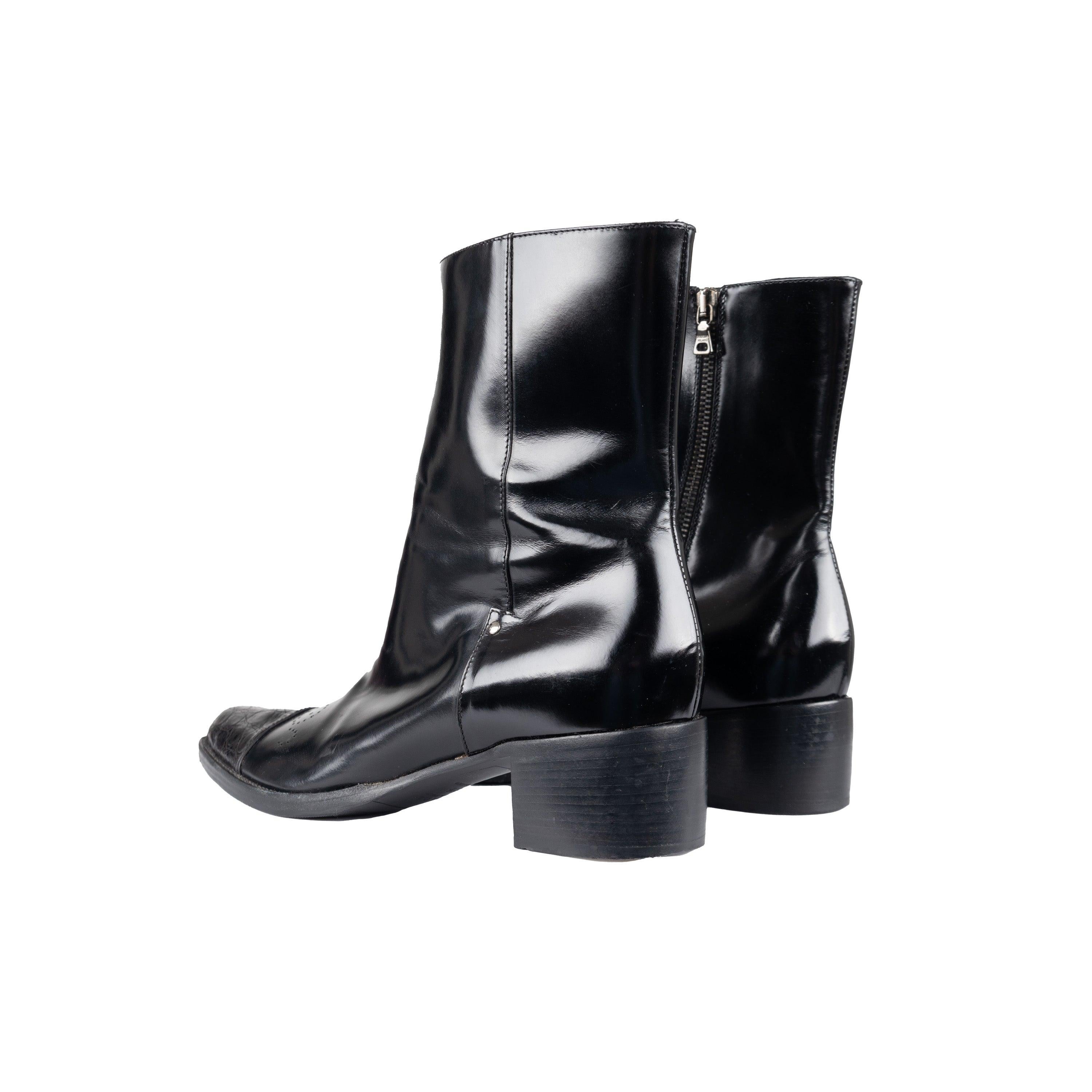 Estos botines Prada con puntera en punta aportan un toque moderno a un estilo atemporal. Confeccionados en charol negro, presentan una punta puntiaguda con un estampado de piel de serpiente en contraste y detalles perforados en la parte superior. Un