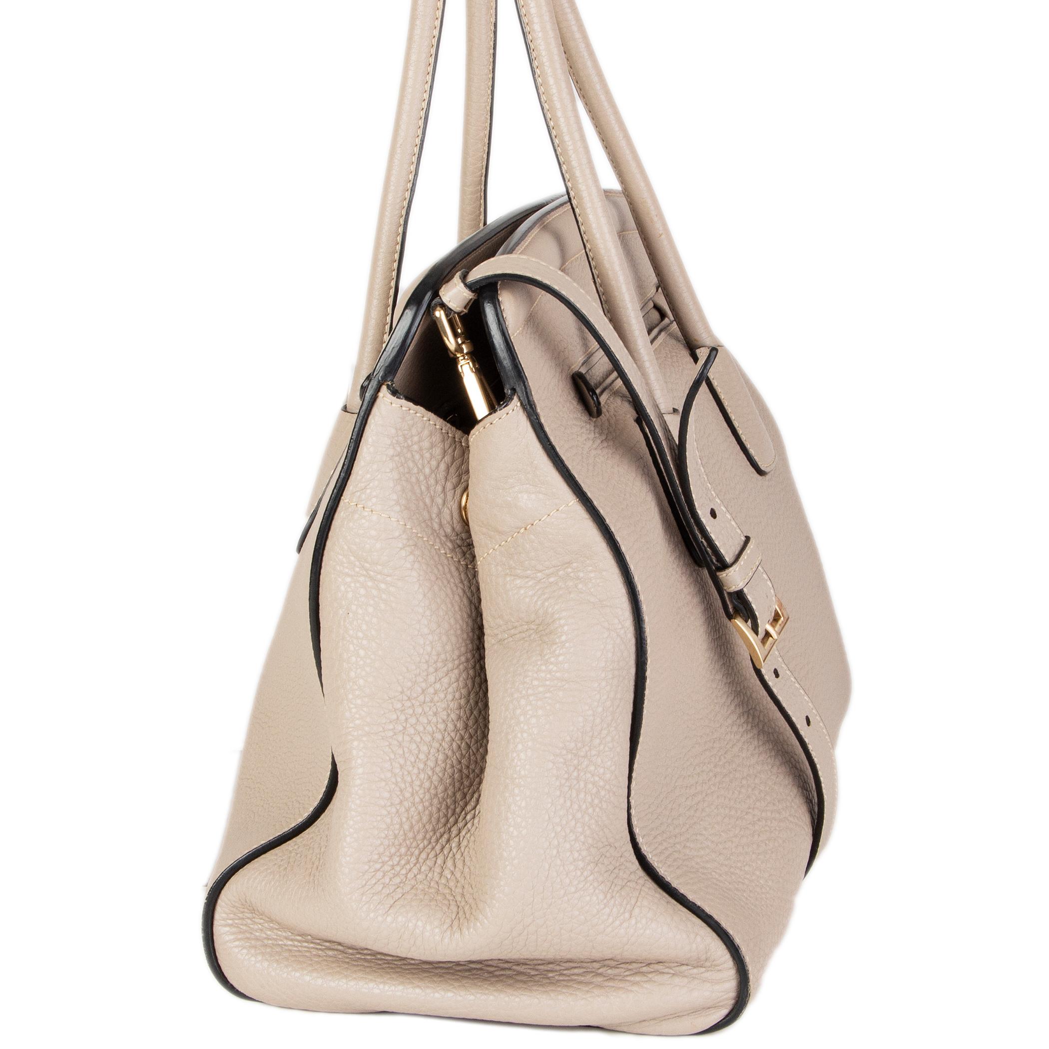 Prada 'BN2571' shoulder bag in Pomice (light taupe) Vitello Daino leather with an open pocket on the front and back. Removable and adjustable shoulder strap. Closes with a snap-button on top. Lined in beige canvas with two open pockets against the