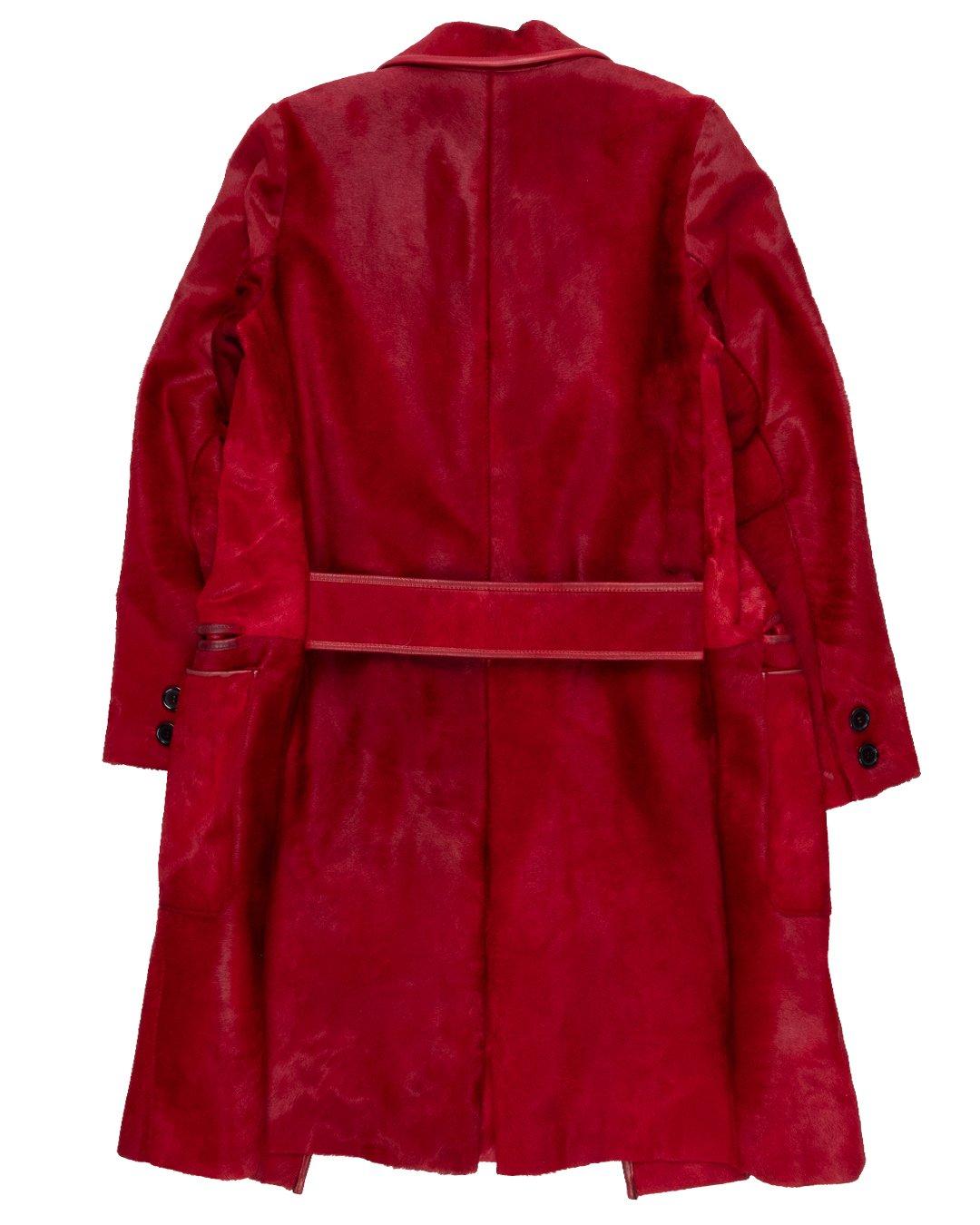 This coat speaks to the sophistication of Muccia Prada’s house, whose straight line cuts and streamlined details render this deep red, pony hair coat not gauche but rather a demure and chic statement.

It features a calf leather trim, large black