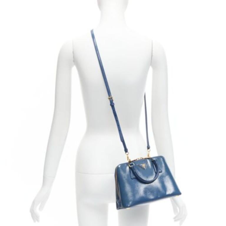 PRADA Promenade Vernice Saffiano blue leather triangle logo top handle tote bag
Reference: CELE/A00016
Brand: Prada
Designer: Miuccia Prada
Model: Promenade
Material: Leather
Color: Blue, Gold
Pattern: Solid
Closure: Zip
Lining: Blue Fabric
Extra