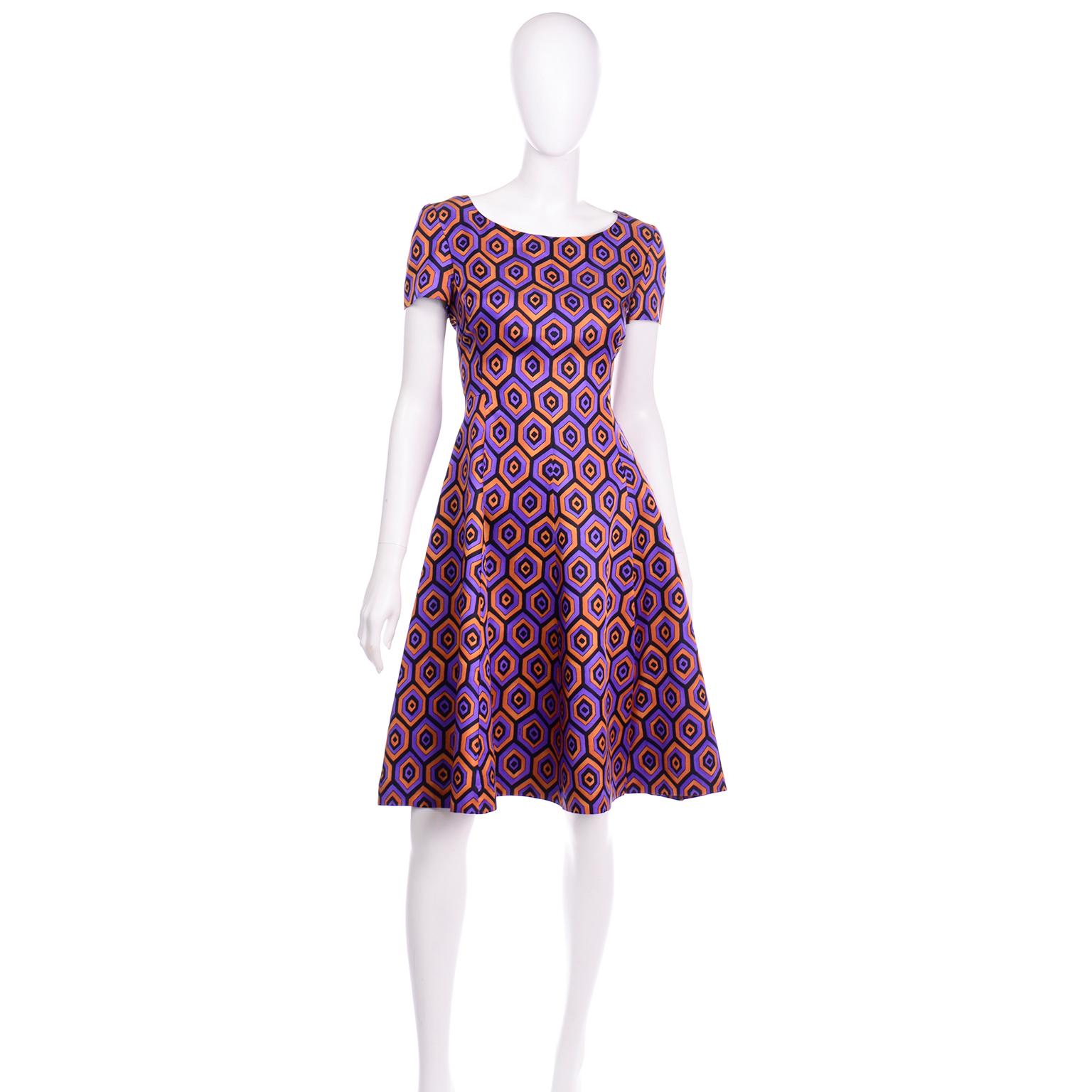 This fun short sleeve Prada dress is in a beautiful purple, orange, and black vertical hexagon pattern. This easy to wear dress has a scoop neckline and the skirt has a slight circle style silhouette. This dress is fully lined and there is a back