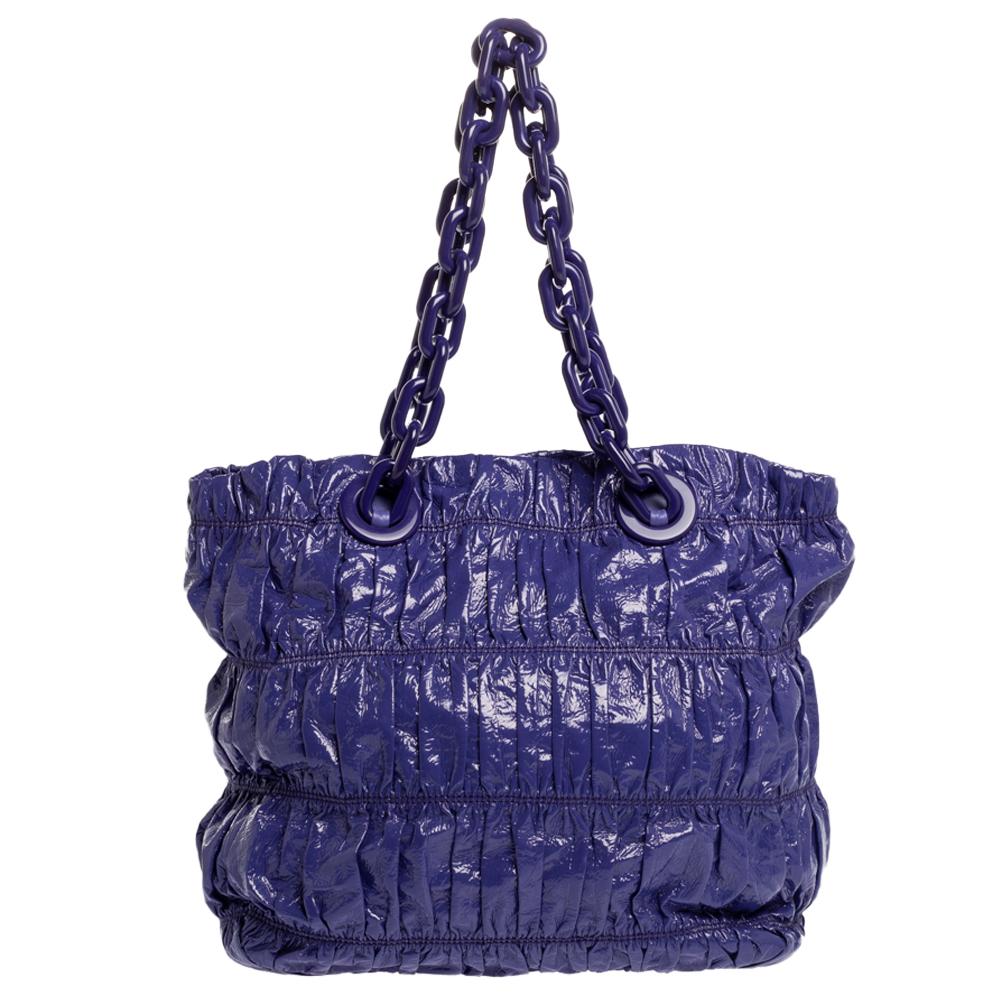 This Prada tote bag features a purple leather body and two chain handles. It has the brand detail on the front and is equipped with a spacious interior. We think it makes a great bag for everyday use.

Includes:Original Dustbag
