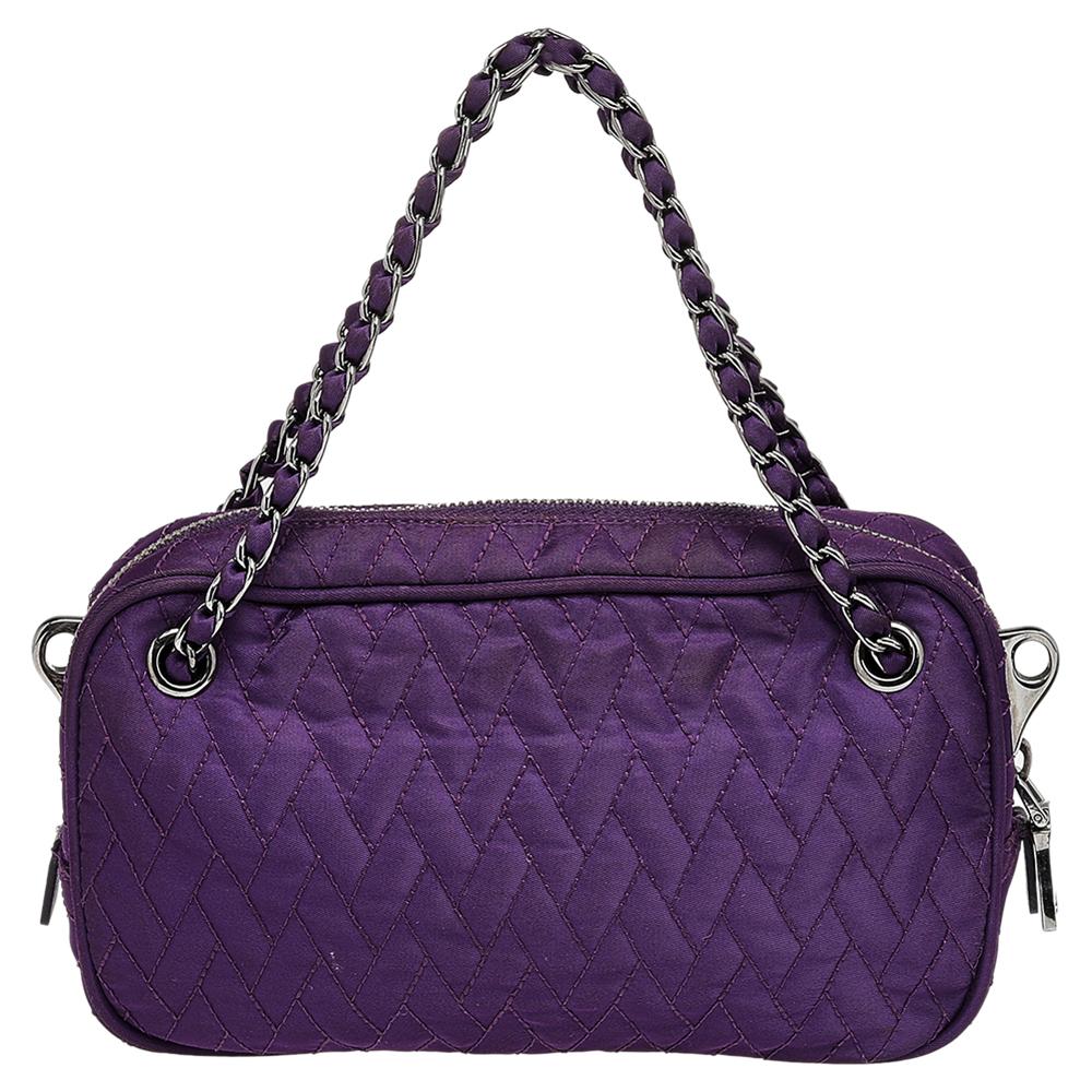 Crafted using purple nylon, this Prada bag features a quilted exterior and the brand label on the front. Two interwoven straps and a leather shoulder strap perfectly complement this sleek and elegant bag.

