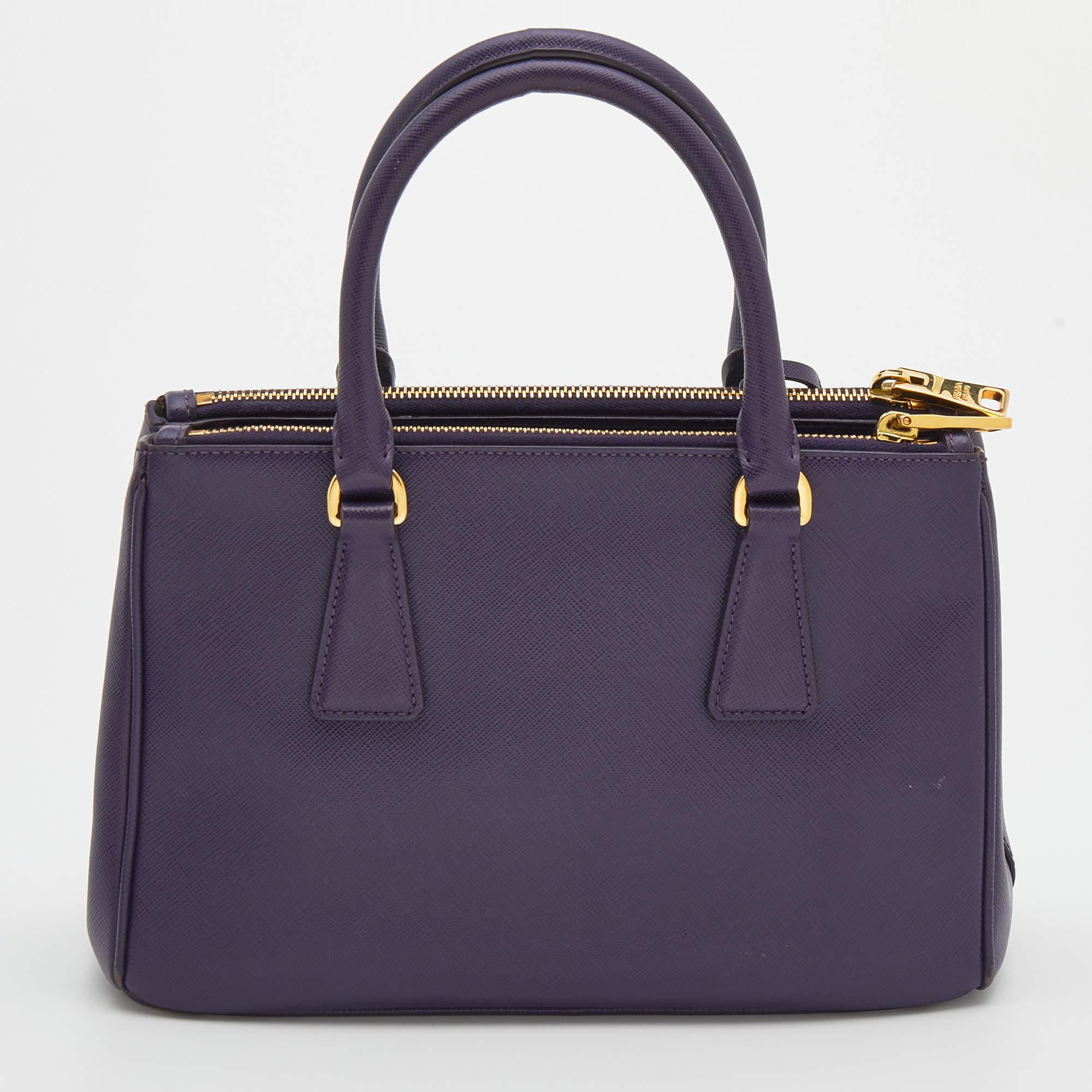 Loved for its classic appeal and functional design, Galleria is one of the most iconic bags from the house of Prada. This beauty in purple is crafted from Saffiano leather and is equipped with two top handles, the brand logo at the front, and a
