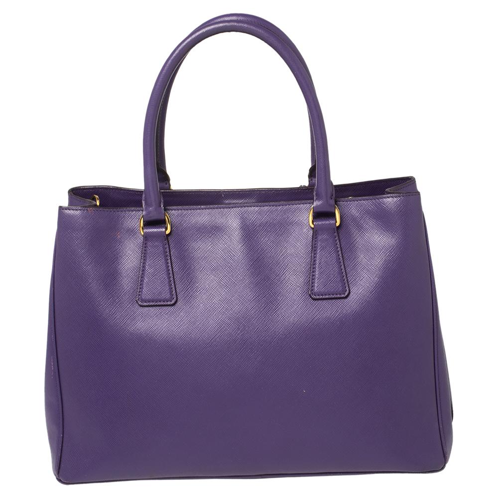 Prada's finest range of totes includes this beauty here. It is crafted in a signature structured silhouette using Saffiano Lux leather and held by two top handles and a detachable shoulder strap. The designer tote is lined with nylon and
