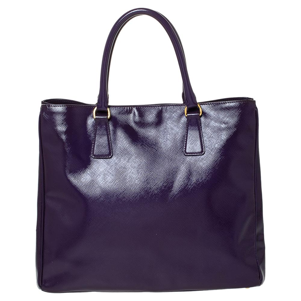 Feel great every time you walk out the door with this well-made Saffiano patent leather bag. With the interior lined in nylon, this bag is spacious and stylish. This admirable Prada tote in a striking hue of purple is hed by two handles and finished
