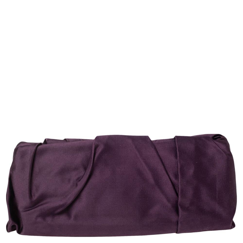 Attend those parties in style by carrying this stunning Raso clutch from Prada. It has been designed in a lovely purple shade and styled with pleat details. It flaunts a gold-tone brand logo on the front and comes endowed with a spacious interior