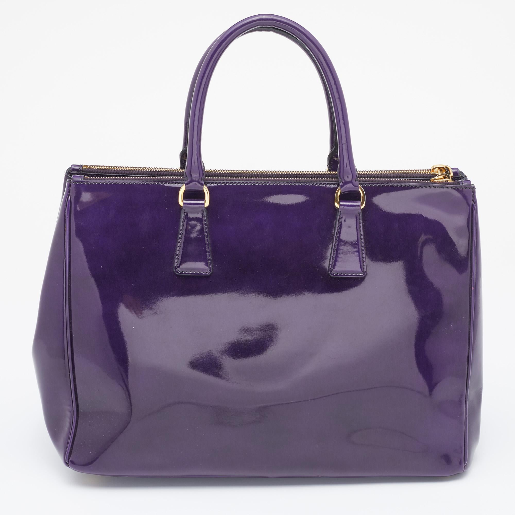 Loved for its classic appeal and functional design, Galleria is one of the most iconic bags from the house of Prada. This beauty in purple is crafted from Spazzolato leather and is equipped with two top handles, the brand logo at the front, and