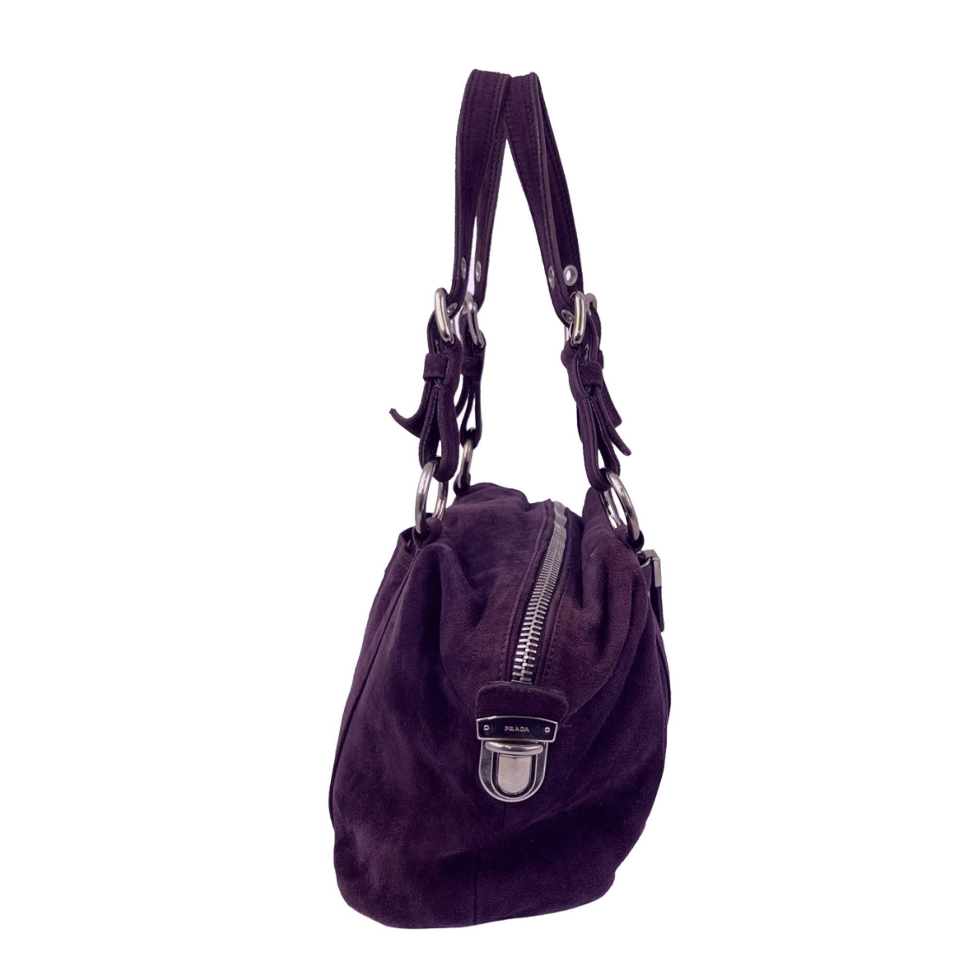 Prada Scamosciato shoulder bag in buttery soft purple suede and silver toned hardware. Features include dual adjustable handles, front zip pocket, back snap pocket, dual top zipper closure with side push buckles for expansion and black Prada logo