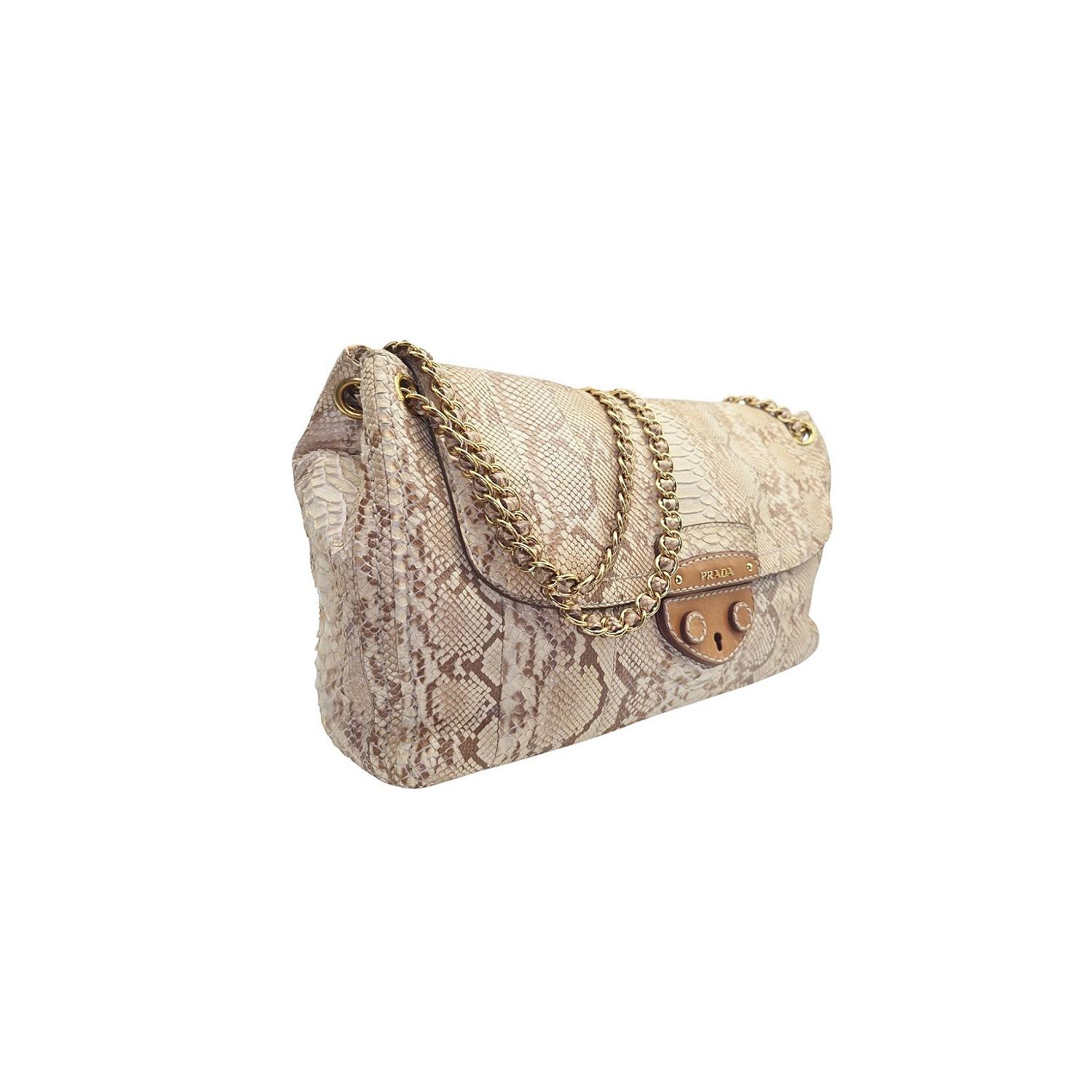 Indulge in unparalleled luxury with the Prada Pitone Delave shoulder bag. Crafted from premium materials, this bag exudes sophistication and exclusivity. The spacious suede interior, threaded chain strap, and gleaming metal logo make it both