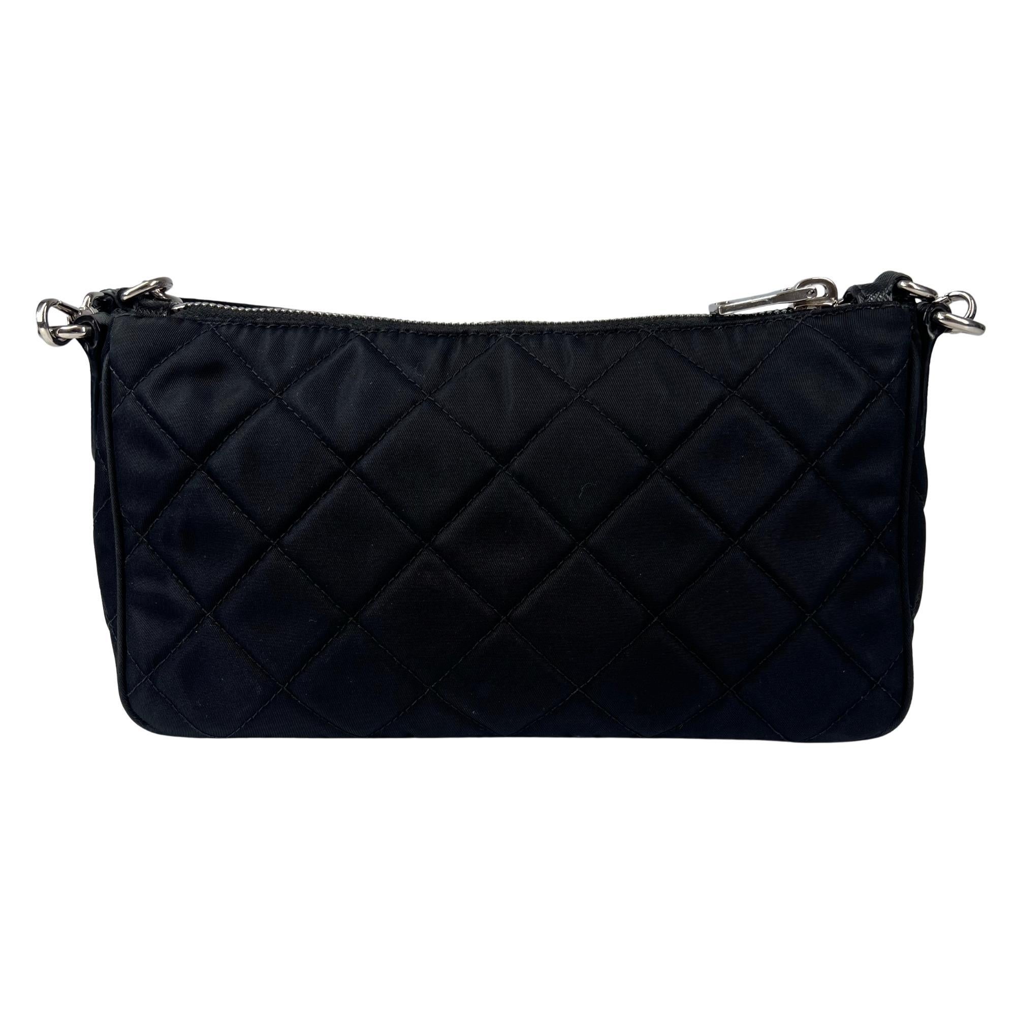 This shoulder bag is made with Prada's signature nylon in quilted black. The bag features top zipper closure, silver-tone hardware and black logo jacquard interior lining. The bag is complete with a chain shoulder strap and an optional leather