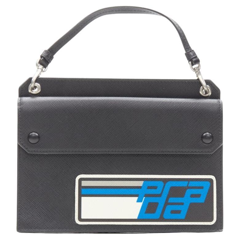 PRADA Racing Graphic Logo black saffiano flap front pocket flat top handle bag For Sale
